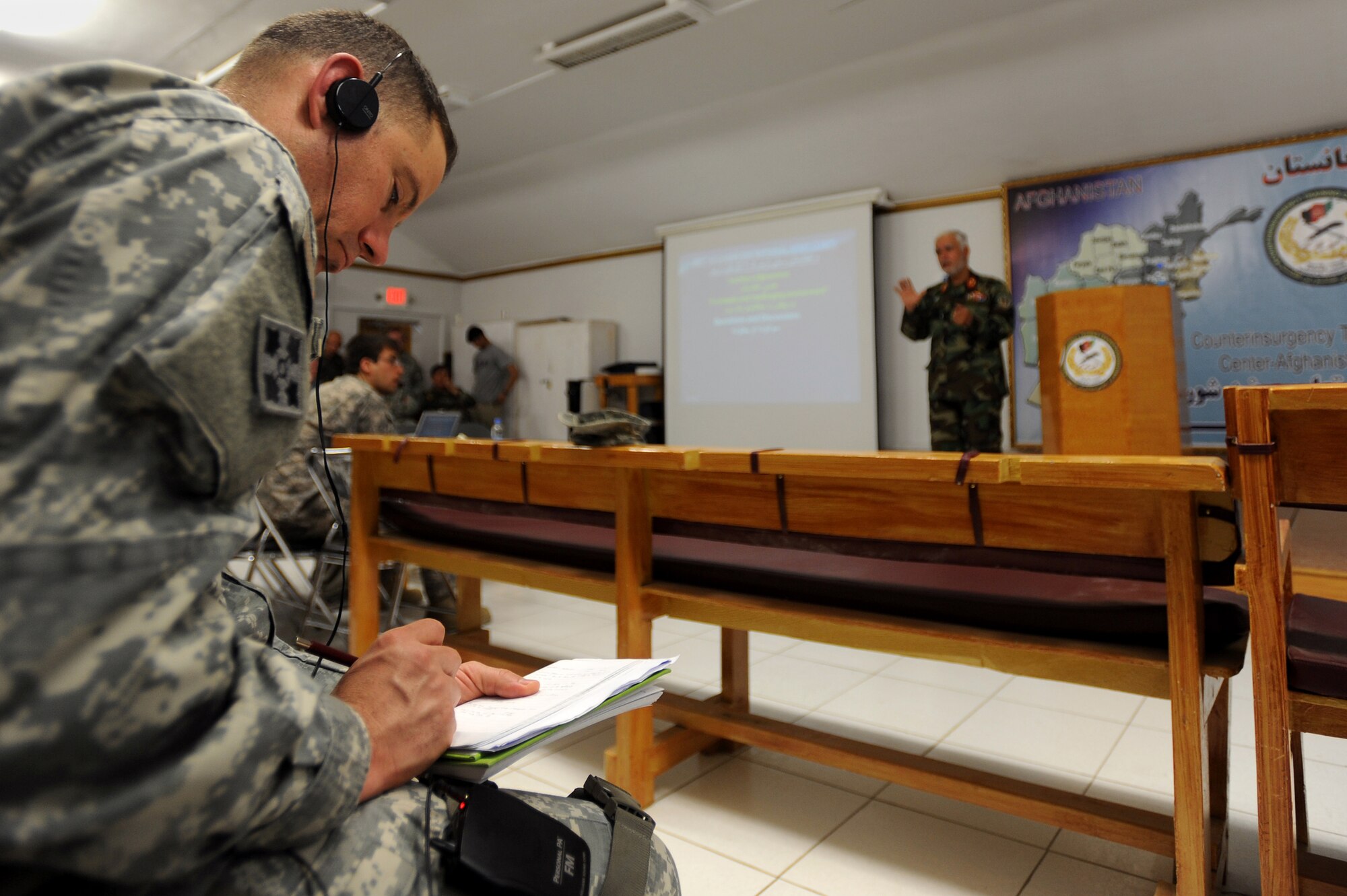 A U.S. Army officer takes notes as Brig. Gen.  Shear Zazai, Afghan National Army 205th Corps commander, speaks at a counterinsurgency (COIN) seminar in Kabul, Afghanistan March 17. The senior officers and non-commissioned officers attended the seminar to gain further knowledge of COIN as Afghan and Coalition troops gear up for combat operations set to take place in Kandahar. (U.S. Air Force photo by Senior Airman Kenny Holston)(Released)
