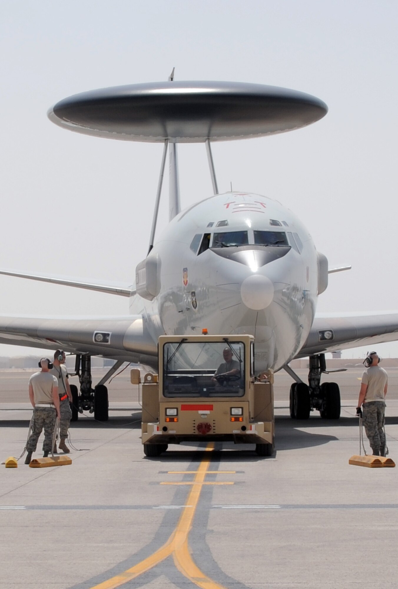Airmen assigned to the 380th Expeditionary Aircraft Maintenance Squadron's Sentry aircraft maintenance unit move an E-3 Sentry Airborne Warning and Control System, or AWACS, aircraft into a parking space on the flightline of a non-disclosed base in Southwest Asia on March 23, 2010. The action comes 33 years to the day when the Air Force received its first E-3 Sentry into its inventory on March 23, 1977. This E-3, assigned to the 965th Expeditionary Airborne Air Control Squadron, along with the maintenance Airmen are deployed to Southwest Asia from the 552nd Air Control Wing at Tinker Air Force Base, Okla. (U.S. Air Force Photo/Master Sgt. Scott T. Sturkol/Released)