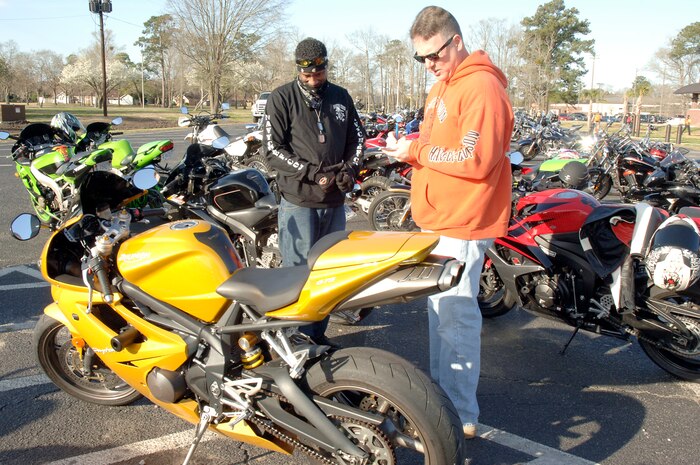 U.S. Air Force Chief Master Sgt. Mike Ivey, right, and U.S. Navy Master Chief Petty Officer Mike Jackson, left, take a close look at a motorcycle during an annual mandatory meeting for all Joint Base Charleston motorcycle riders, which kicked off Air Mobility Command?s Spring Safety Focus March 19, 2010 at the base theater. A competition was held where the first and second place winners were announced which showcased the best bikes out of 134 cruisers and sports bikes. Chief Ivey is the 628th Air Base Wing command chief and Chief Jackson is the Naval Weapons Station Charleston command master chief. (U.S. Air Force photo/Staff Sgt. Marie Brown)