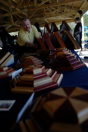Jerry Amadon prepares his table of coin holders, shadow boxes and other military display cases at a base-wide yard sale and arts and crafts festival March 20, 2010, at Joint Base Charleston, S.C. After the base-wide event finished, many donated their unsold items to the Airmen's Attic for Airmen just starting out at the base, rather than being used for a later sale. Mr. Amadon spent 24 years in the Air Force, retiring as a master sergeant with the 437th Civil Engineer Squadron. (U.S. Air Force photo/Senior Airman Timothy Taylor)