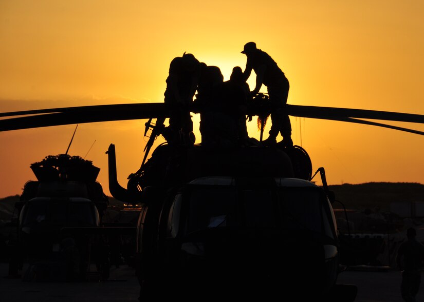 Deployed members from 1st Battalion, 228th Aviation Regiment race against the sun to get their UH-60s unfolded and operationally ready March 21. The 1-228th along with other members of Joint Task Force-Bravo from Soto Cano Air Base, Honduras deployed in support of Joint task Force-Haiti March 21 and 22. (U.S. Air Force photo/Staff Sgt. Bryan Franks)