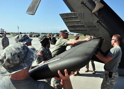 Members from the 1st Battalion, 228th Aviation Regiment install the stabilator to a UH-60 Blackhawk after unloading it from a C-17 Globemaster III March 21. The 1-228th along with other members of Joint Task Force-Bravo from Soto Cano Air Base, Honduras deployed to Haiti in support of Joint task Force-Haiti March 21 and 22. (U.S. Air Force photo/Staff Sgt. Bryan Franks)