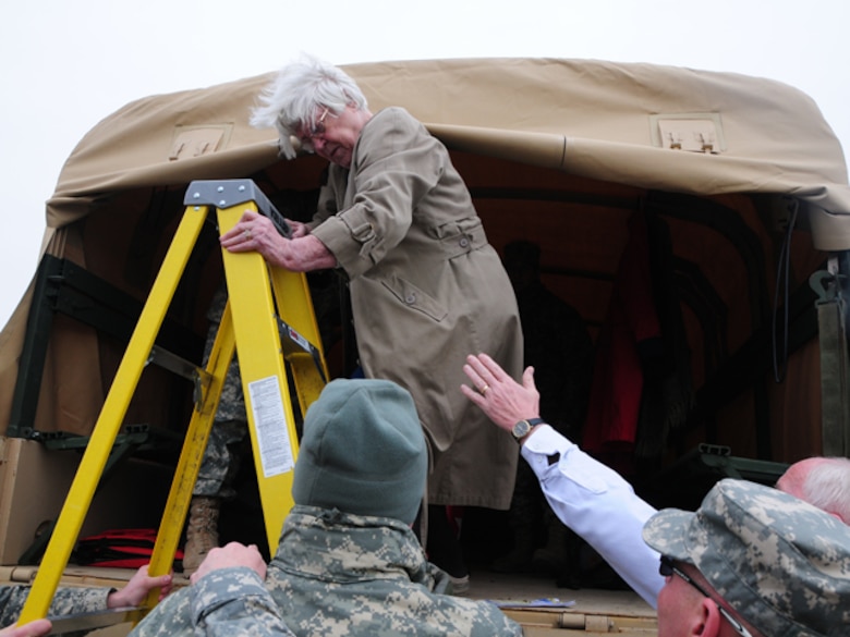 Cass County Sherriff's Department Chief Deputy Jim Thoreson and members of the 815th Engineer Company help Mili Sherman down a ladder and out of a North Dakota National Guard quick response force (QRF) truck March 22, in rural Cass County.  Thorson and the QRF team are assisting Sherman to temporarily vacate her home because the rising over-land flood water covering her access road has made it dangerous to drive in and out of her roadway.


