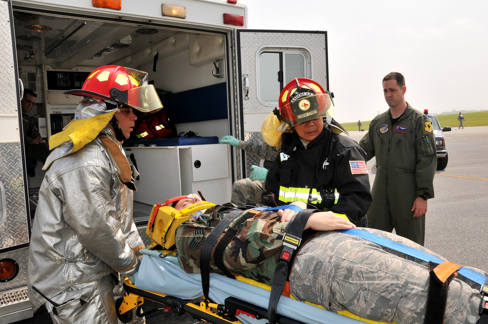 Members from the Kadena Fire Department transport a victim to medical personnel for treatment in a simulation involving an Airborne Warning and Control System E-3 Sentry engine fire during Beverly High 10-02 at Kadena Air Base, Japan, March 23.  The 18th Wing is participating in a Local Operational Readiness Exercise March 22-26 to test the readiness of Kadena Airmen. (U.S. Air Force photo/Tech. Sgt. Angelique Perez)       