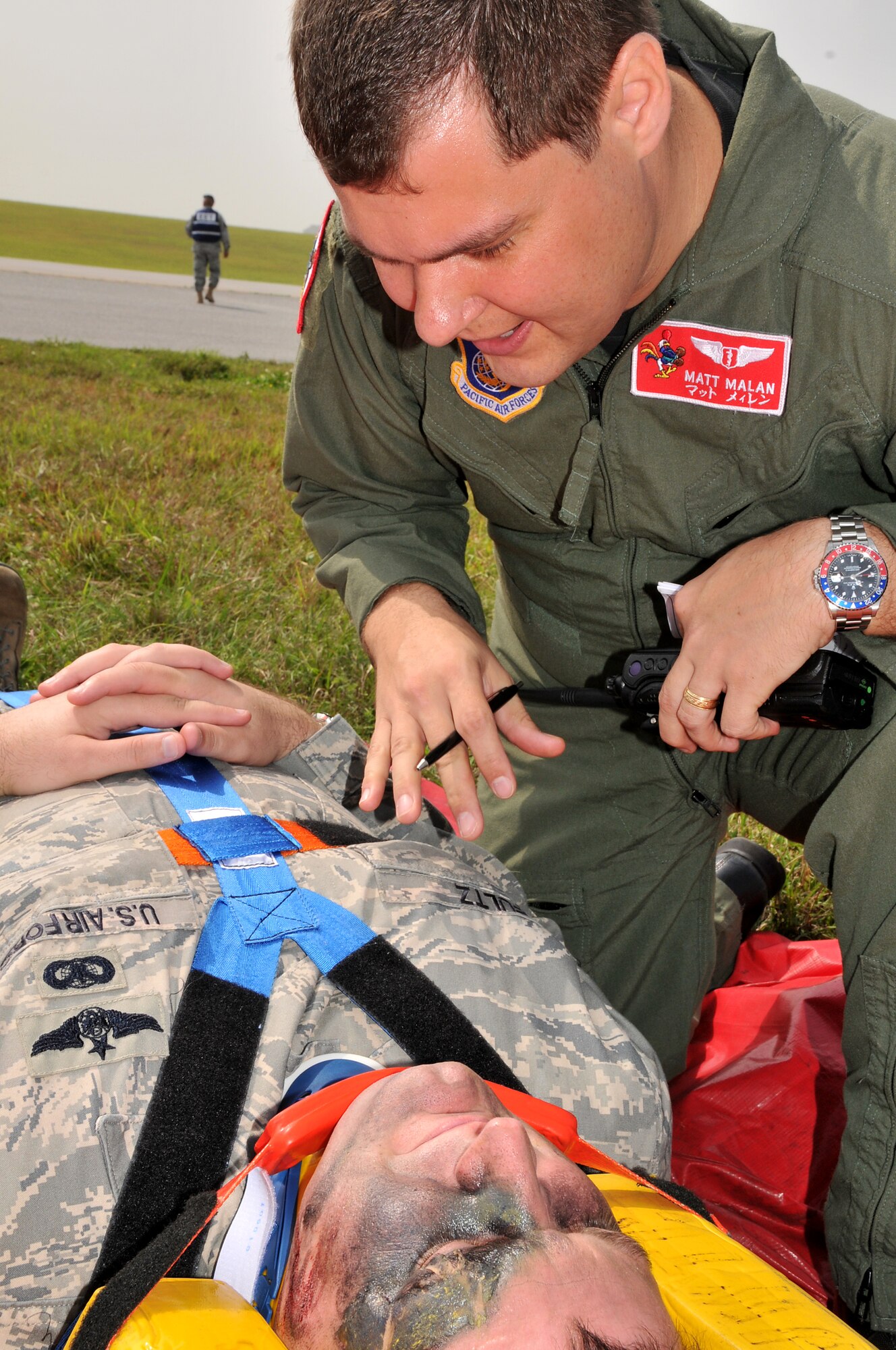 Maj. Matthew Malan, 18th Aerospace Medicine Squadron flight surgeon, checks the victims vital signs in a simulation involving an Airborne Warning and Control System E-3 Sentry engine fire during Beverly High 10-02 at Kadena Air Base, Japan, March 23.  The 18th Wing is participating in a Local Operational Readiness Exercise March 22-26 to test the readiness of Kadena Airmen. (U.S. Air Force photo/Tech. Sgt. Angelique Perez)       