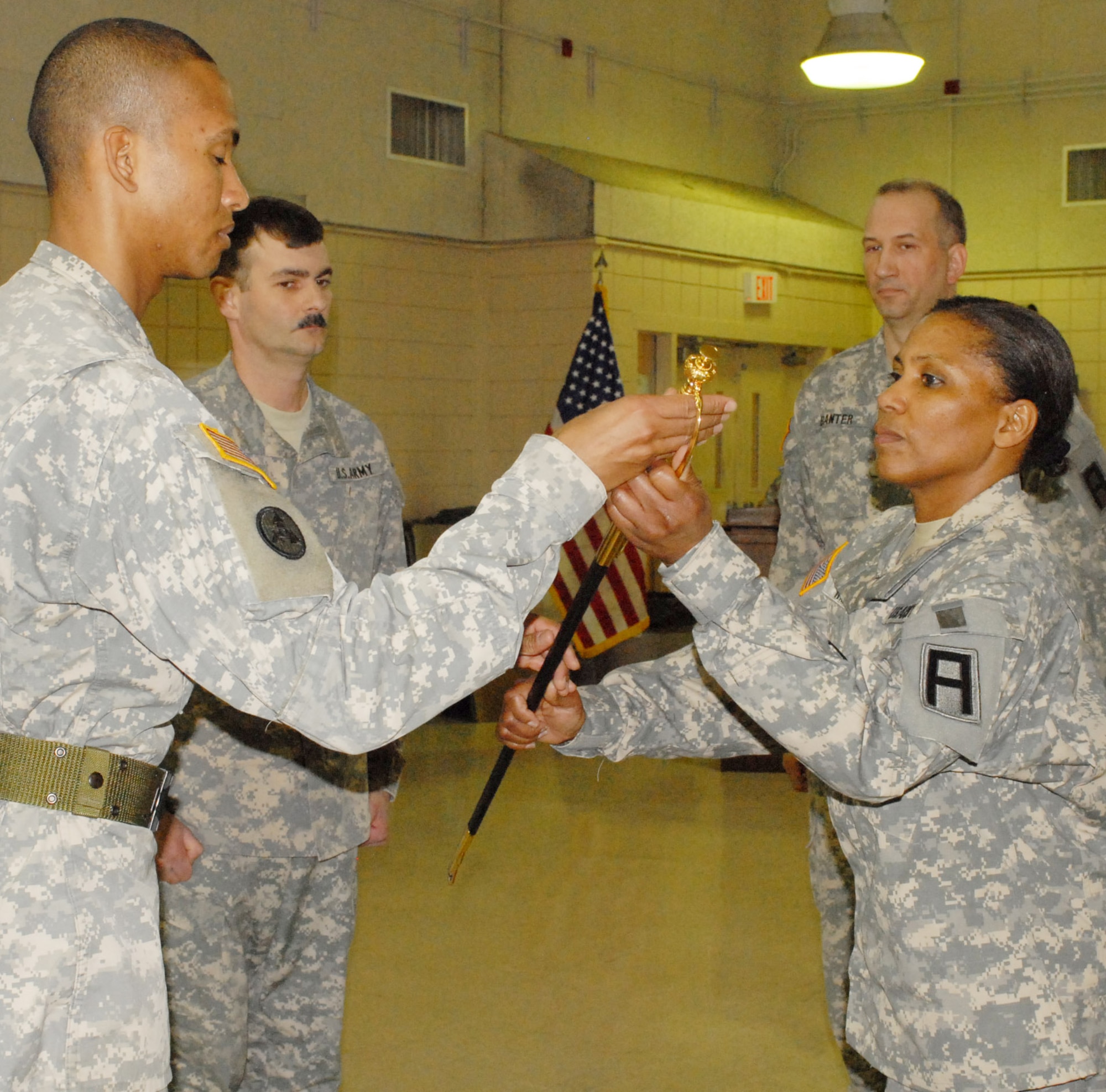Incoming first sergeant for Headquarters and Headquarters Battery, 72nd Field Artillery Brigade, 1st Sgt. Darlene White passes the ceremonial non-commissioned officers sword to the colors sergeant, Sgt. 1st Class Guelmy Gloss, during the change of responsibility ceremony at the Kelley Reserve Center here March 12.(U.S. Army photo/Sgt. Nicole Dykstra).