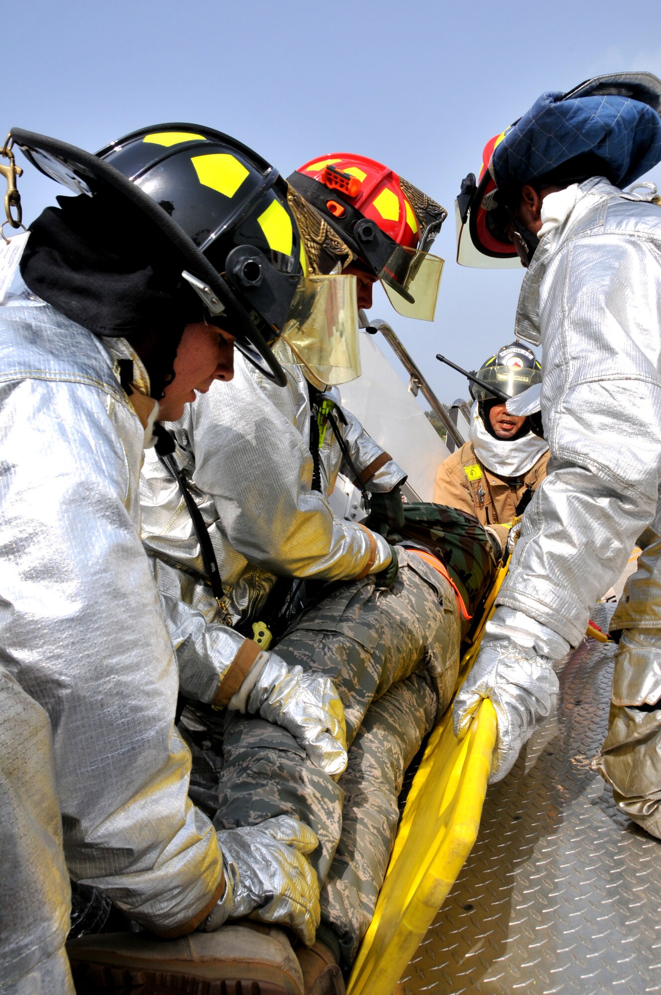 The Kadena Fire Department extract an injured victim in a simulation involving an Airborne Warning and Control System E-3 Sentry engine fire during Beverly High 10-02 at Kadena Air Base, Japan, March 23.  The 18th Wing is participating in a Local Operational Readiness Exercise March 22-26 to test the readiness of Kadena Airmen. (U.S. Air Force photo/Tech. Sgt. Angelique Perez)      
