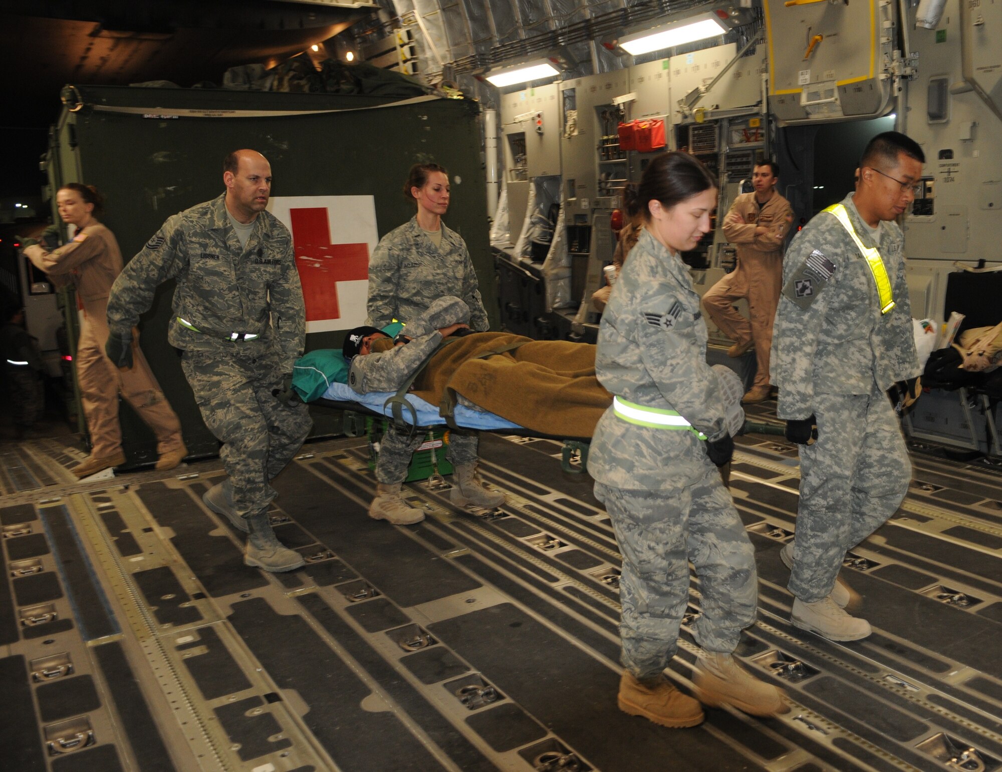 Contingency Aeromedical Staging Facility staff and volunteers load litter patients aboard a C-17 aeromedical evacuation flight to Germany, March 17, 2010. (U.S. Air Force photo by Senior Master Sgt. Stefan Alford/Released)