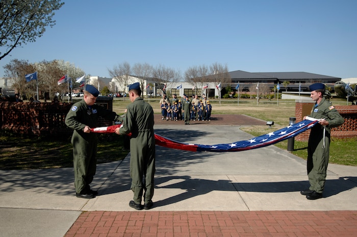 Staff Sgt. Matt Johnson, left, Senior Airman Derrick Maloney, center, and Senior Airman Donald Mekeel fold the American flag at a retreat ceremony with local Cub Scouts participating in the formation March 19, 2010, at Joint Base Charleston, S.C. The Cub Scouts participated in the retreat after 17th Airlift Squadron Commander Lt. Col. Richard Williamson spoke with their Den Leader, Walley Mann, about the educational opportunity it would present. Sergeant Johnson, Airman Maloney and Airman Mekeel are loadmasters with the 17 AS. (U.S. Air Force photo/Senior Airman Timothy Taylor)