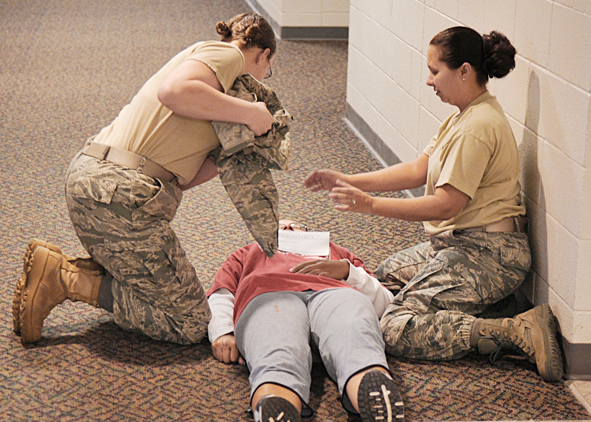 Airmen perform self-aid and buddy care on a woman who suffered a simulated gunshot wound at the Domenici Fitness and Sports Center March 11, 2010, at Holloman Air Force Base, N.M. The goal of the exercise was to evaluate how well base Airmen are prepared for an active shooter scenario on the installation. (U.S. Air Force photo/Staff Sgt. Anthony Nelson Jr.)
