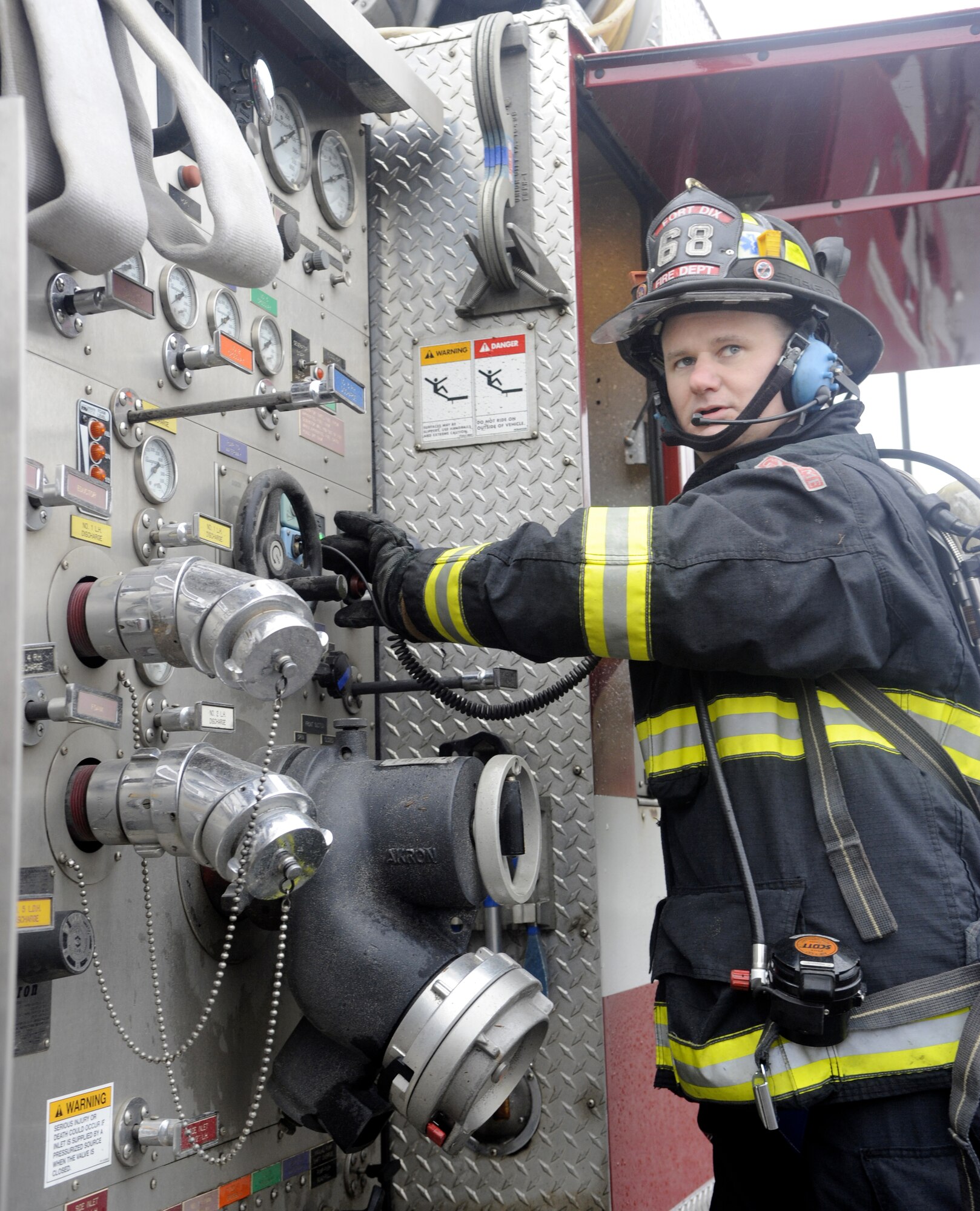 A firefighter from Joint Base McGuire-Dix-Lakehurst checks water pressure and other equipment on the control panel of a fire engine during a HAZMAT Crisis Exercise March 15. The exercise simulated a vehicle accident and chemical spill that prompted emergency first responders such as police, fire, medical and HAZMAT teams. (U.S. Air Force photo/Carlos Cintron)
