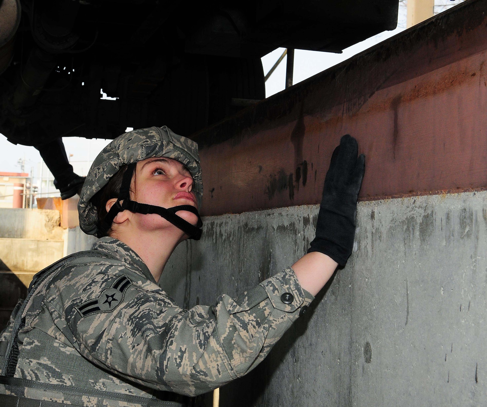 YOKOTA AIR BASE, Japan -- Airman 1st Class Melissa Burazin, 374th Security Forces Squadron patrolman, checks the underside of a cargo vehicle during a routine security check. Security Forces Airmen routinely check cargo vehicles for suspicious materials. (U.S. Air Force photo/Airman 1st Class Lynsie Lorenz)

