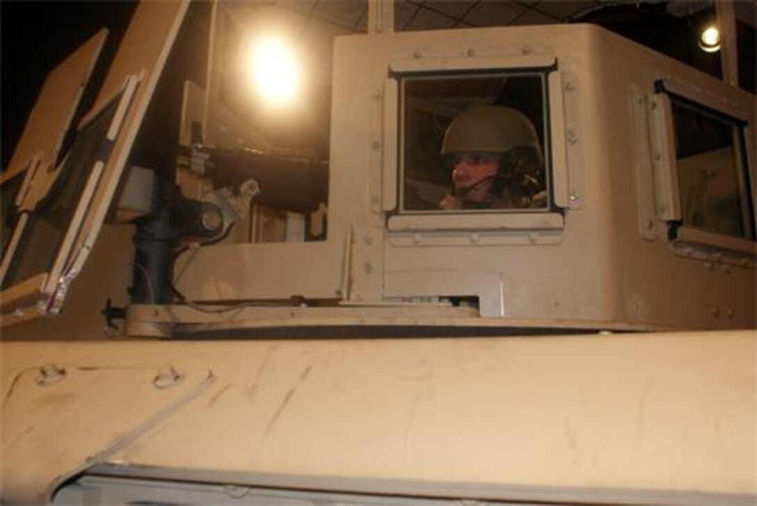 Sgt. Jonathan Tanner, White House Transportation Agency master driver, stands look-out inside the High Mobility Multi-purpose Wheeled Vehicle machine gun mount during the Improvised Explosive Device Battle Drill simulator Feb. 18 at the Eustis IED simulator training facility. 
(Photo by Tetaun Moffett)