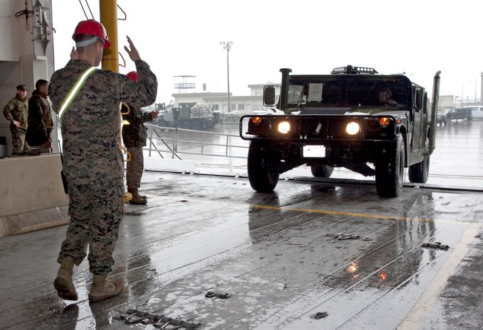Warrant Officer Bradley Gilmer, the mobilty officer for Marine Wing Support Squadron 171 loads vehicles and supplies onto a high speed vessel before departing with Combat Logistics Squadron 36 for the South Korean peninsula Mar. 23. MWSS 171 and CLC-36 will be supporting exercises Key Resolve/Foal Eagle for approximately two months.