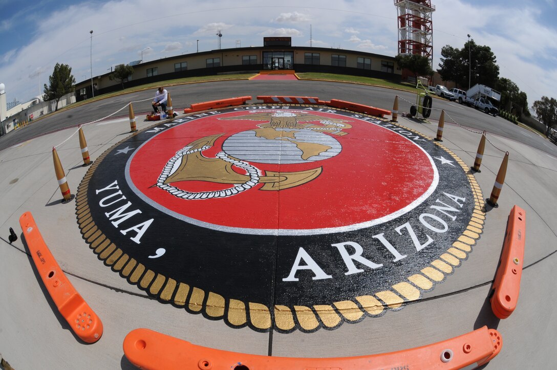 The newly painted emblem on the flight line at the Marine Corps Air Station in Yuma, Ariz., dries in front of the operations building March 23, 2010. The emblem was repainted to replace the old worn emblem which was last painted in 2006. “The old emblem was looking very cartoony,” said Jackie Emo, owner of Desert Signs, the company contracted to paint the emblem. The repainting took nine days to complete.