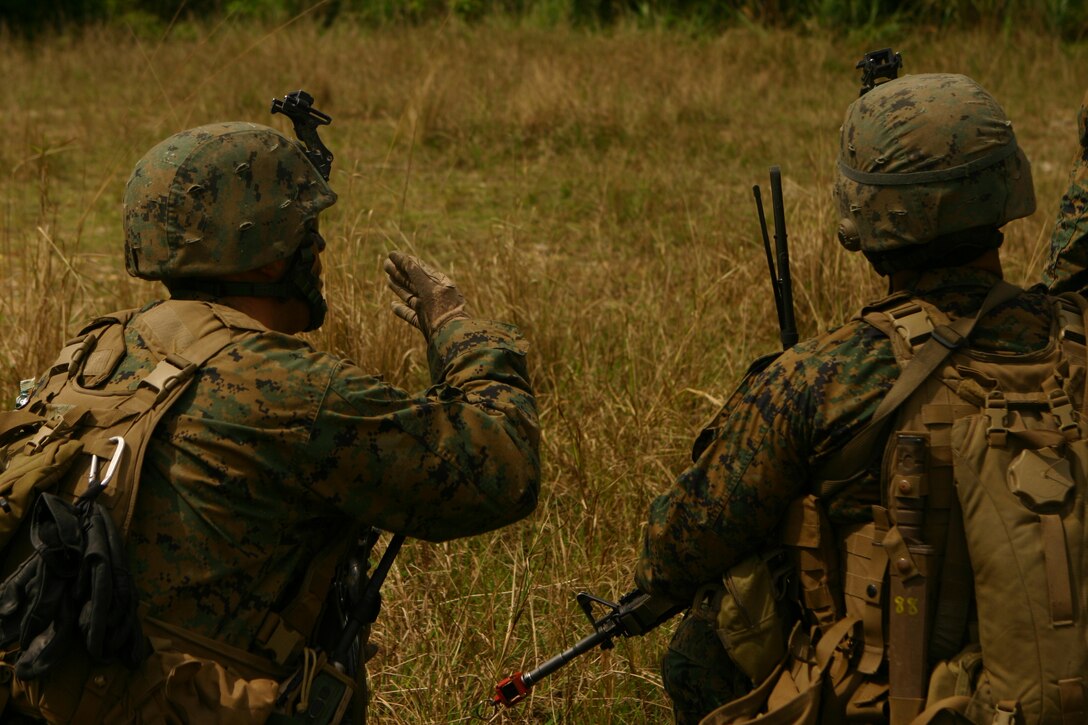 Marines with Battalion Landing Team 2nd Battalion, 7th Marines(BLT 2/7), 31st Marine Expeditionary Unit (MEU), discuss a movement plan during a simulated helicopter raid at landing zone Dodo, March 24. The MEU conducted a tactical offload consisting of a mechanized raid, boat raid, helicopter raid and a humanitarian assistance and disaster relief (HA/DR) exercise. This is the first time that the MEU conducted  a tactical offload in Okinawa, Japan. (Official Marine Corps photo by Cpl. Michael A. Bianco)