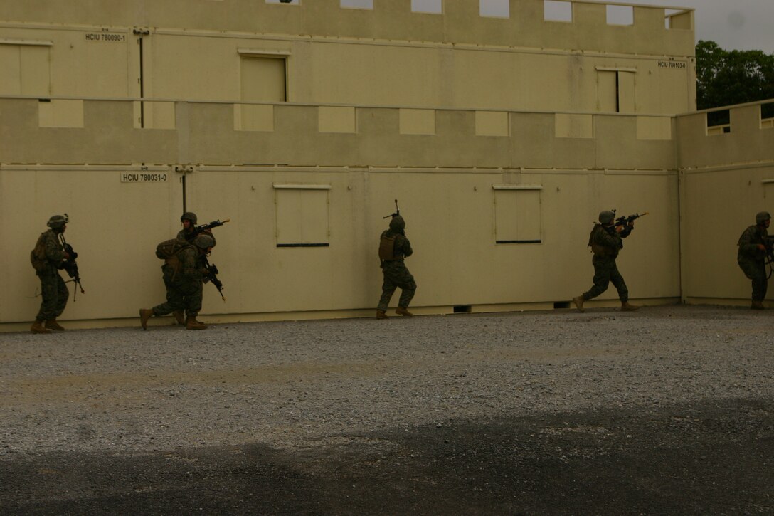 Marines with Battalion Landing Team 2nd Battalion, 7th Marines(BLT 2/7), 31st Marine Expeditionary Unit (MEU), assault a building occupied by opposing forces during a simulated helicopter raid at landing zone Dodo, March 24. The MEU conducted a tactical offload consisting of a mechanized raid, boat raid, helicopter raid and a humanitarian assistance and disaster relief (HA/DR) exercise. This is the first time that the MEU conducted  a tactical offload in Okinawa, Japan. (Official Marine Corps photo by Cpl. Michael A. Bianco)