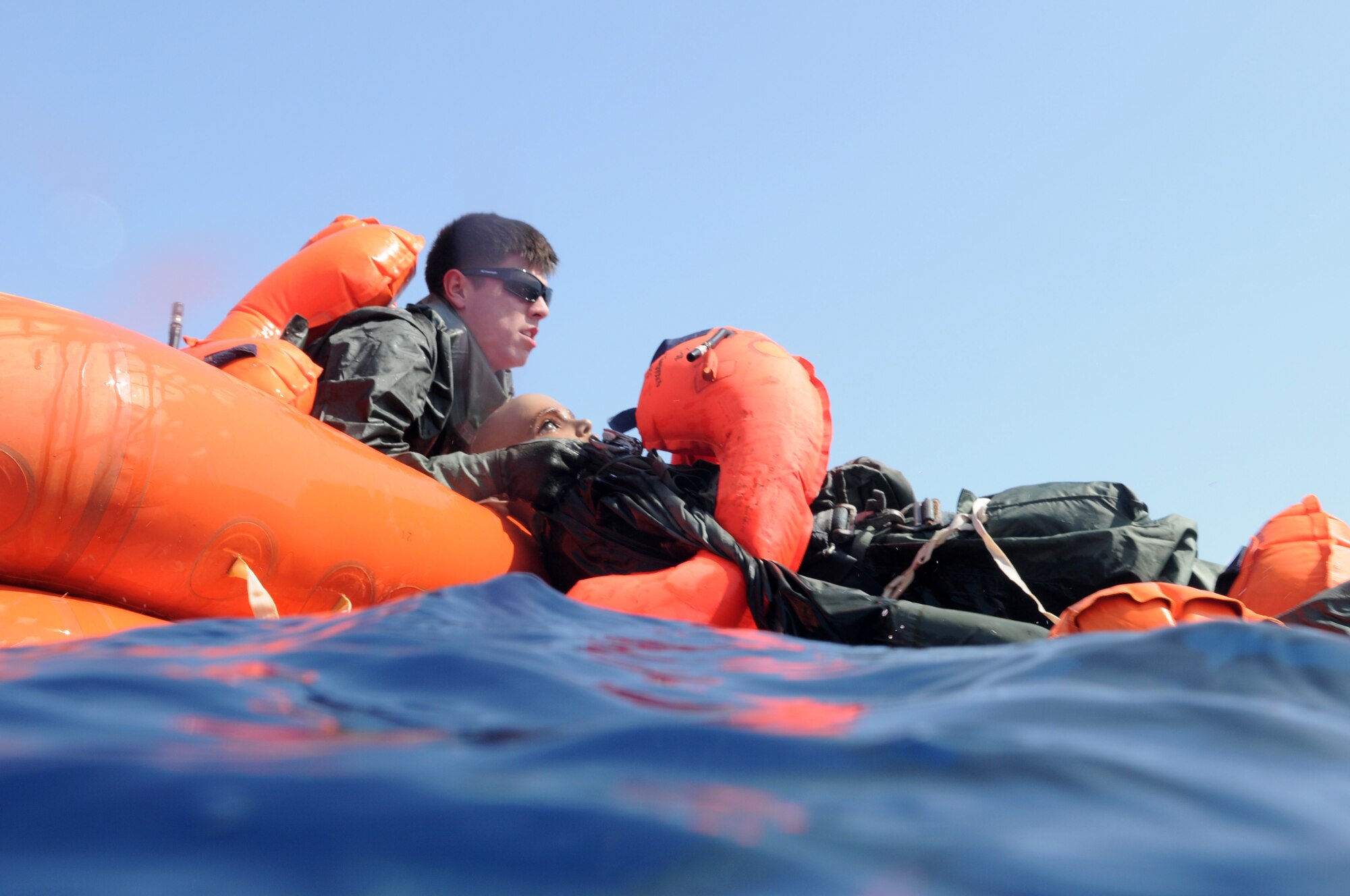 Senior Airman James Sharp, a member of the 961st Airborne Air Control Squadron, pulls a “victim” into a life raft to start self aid and buddy care during a simulated aircraft emergency water landing at Kadena Air Base, Japan, March 24. Members of the 961st AACS spent the afternoon training proper emergency landing and water survival procedures. The training was part of Beverly High 10-02, a Local Operational Readiness Exercise designed to evaluate the readiness of Kadena Airmen. (U.S. Air Force photo/Senior Airman Amanda N. Grabiec)