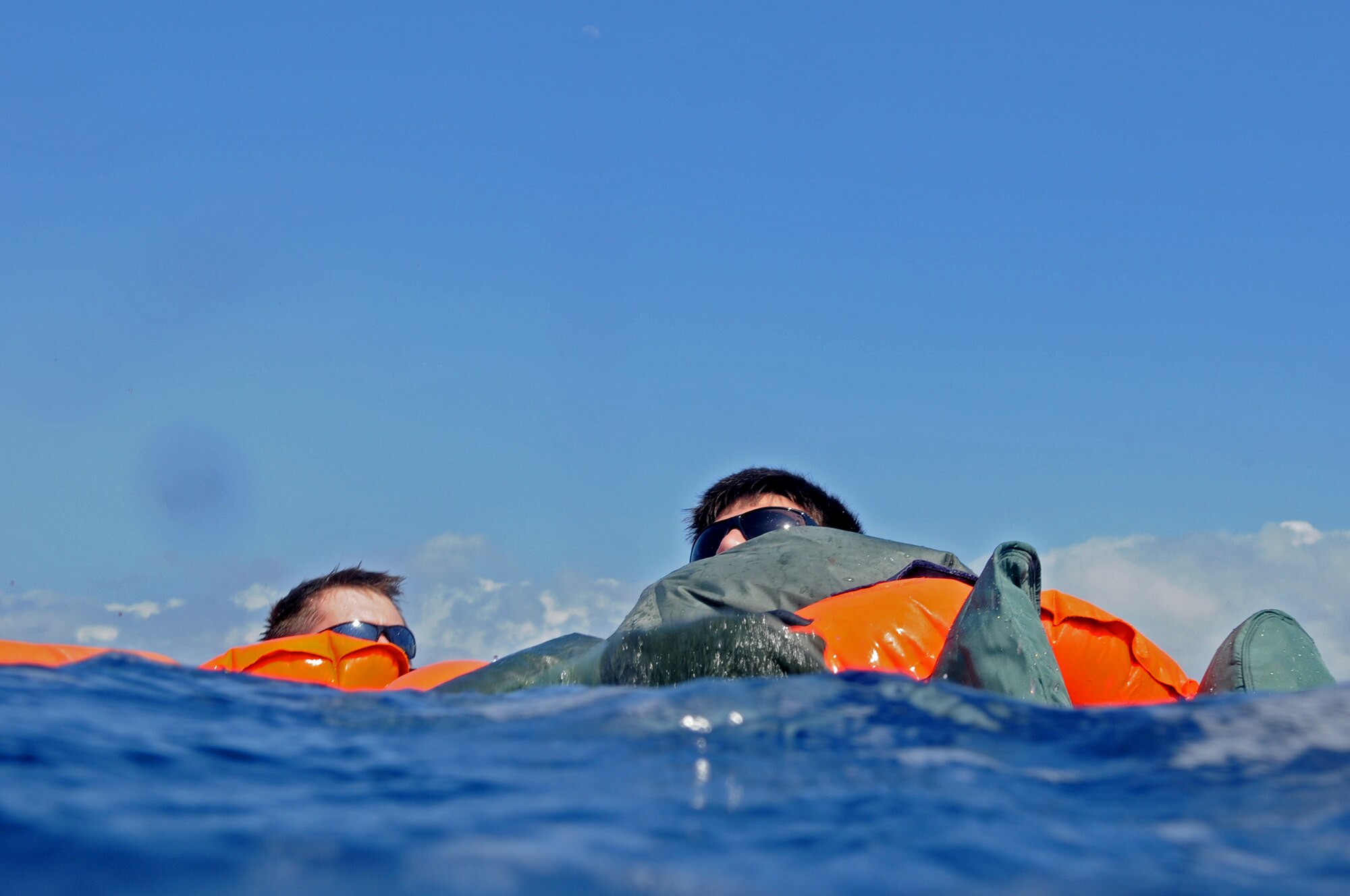 First Lieutenant Steve Jensen (left) and Senior Airman James Sharp (right), both members of the 961st Airborne Air Control Squadron, swim to a life raft during a simulated aircraft emergency water landing at Kadena Air Base, Japan, March 24. Members of the 961st AACS spent the afternoon training proper emergency landing and water survival procedures. The training was part of Beverly High 10-02, a Local Operational Readiness Exercise designed to evaluate the readiness of Kadena Airmen. (U.S. Air Force photo/Senior Airman Amanda N. Grabiec)