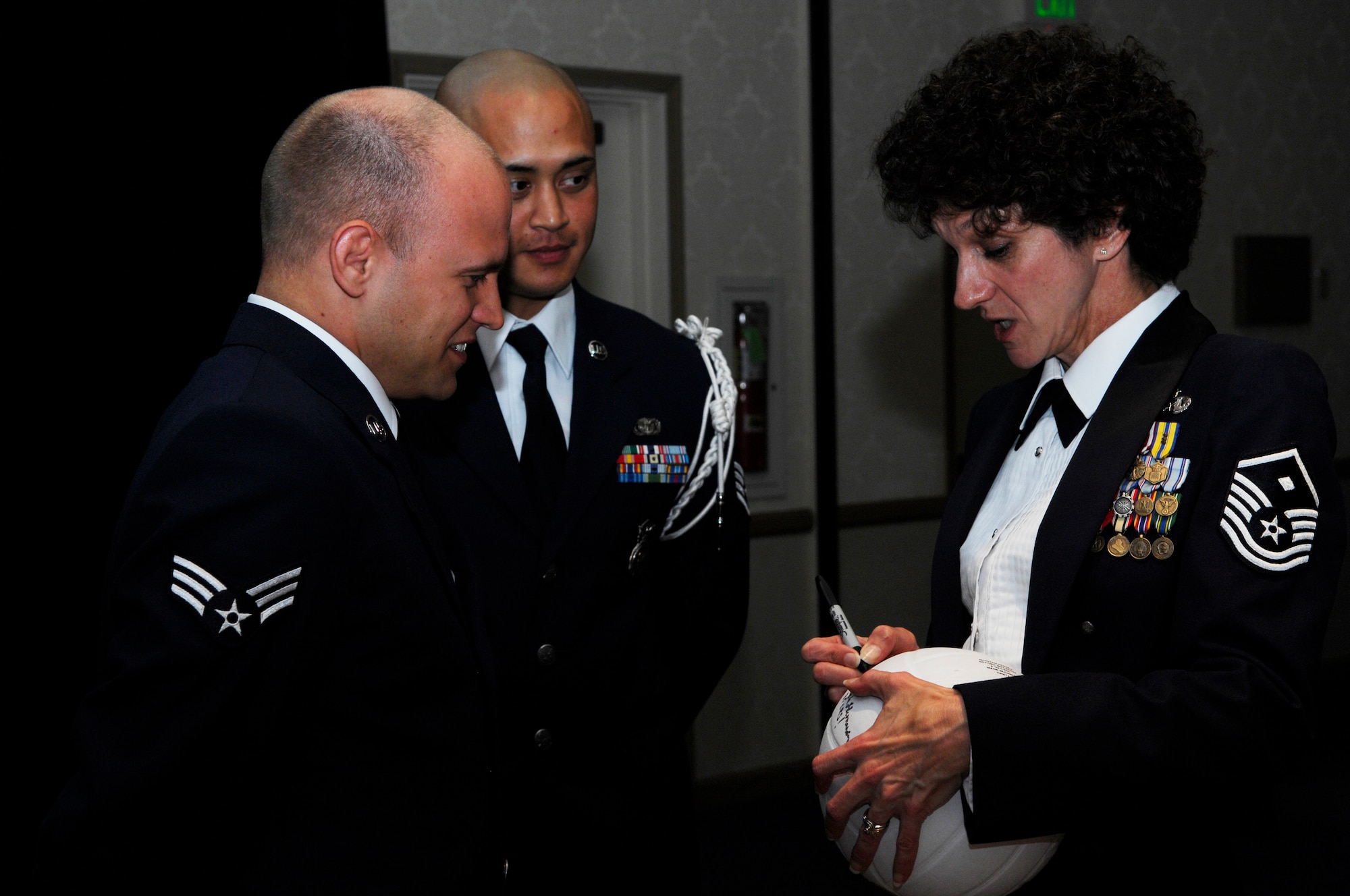 VANDENBERG AIR FORCE BASE, Calif. -- Master Sgt. Shari Colquhoun, the 30th Force Support Squadron first sergeant, signs the volleyball at Airman Leadership School graduation here Tuesday, March 23, 2010 after it was presented in honor of the first sergeants' win against the ALS students. The first sergeants remain undefeated. (U.S. Air Force photo/Senior Airman Heather R. Shaw)

