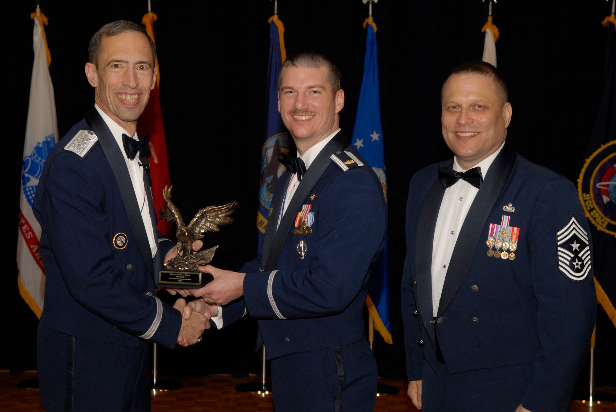 VANDENBERG AIR FORCE BASE, Calif. -- Maj. Jason Terry, with the Joint Functional Component Command for Space, receives the JFCC Space Field Grade Officer Annual Award from Lt. Gen. Larry James, the 14th Air Force commander, and Chief Master Sgt. James MacKinley, the 14th AF command chief master sergeant, during the 14th Air Force Annual Awards Ceremony at the Pacific Coast Club here Thursday, March 18, 2010.   (U.S. Air Force photo/Senior Airman Andrew Satran) 

 
 