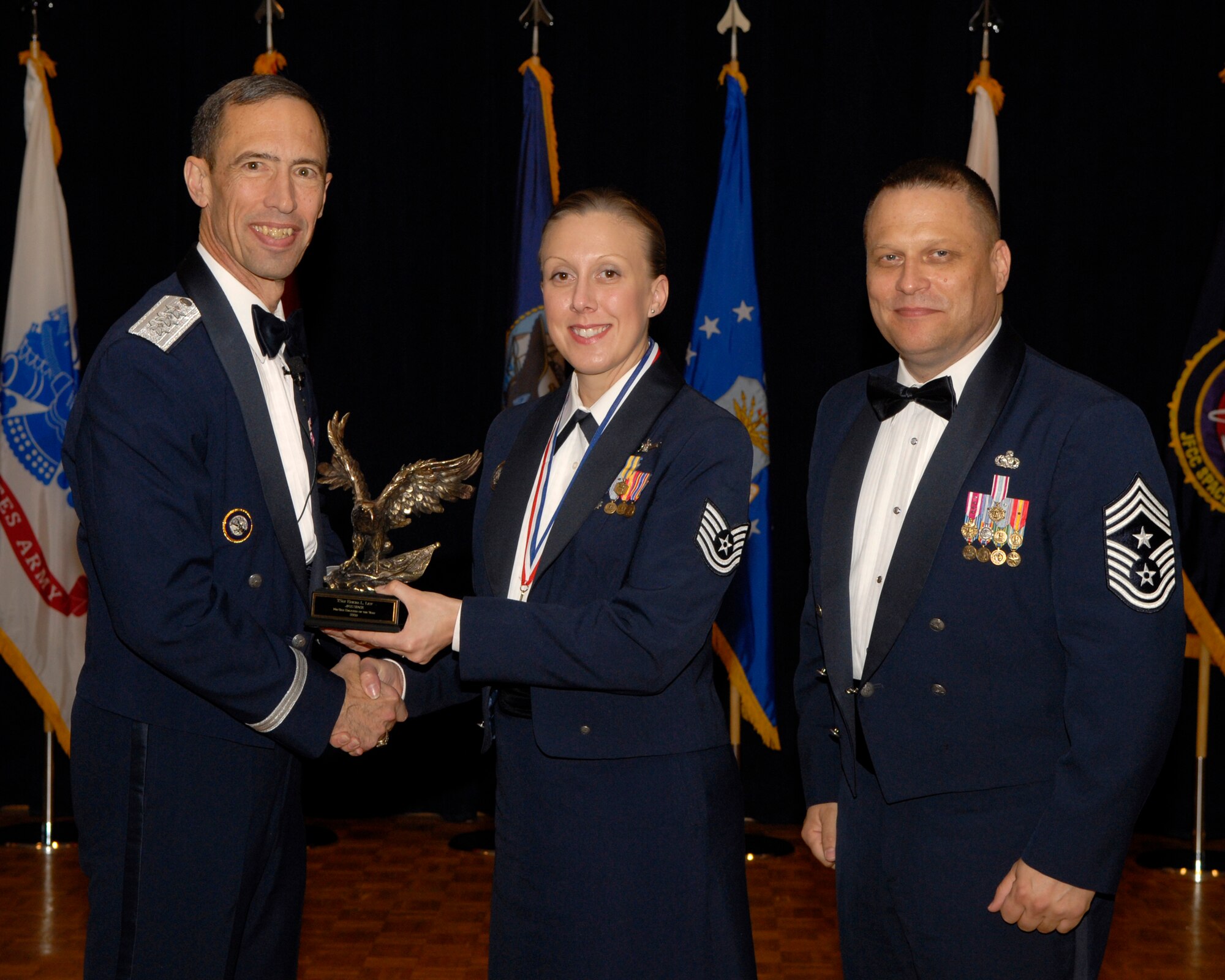 VANDENBERG AIR FORCE BASE, Calif. -- Tech. Sgt. Erica List, with the Joint Functional Component Command for Space, receives the JFCC Space Mid-Tier Enlisted Annual Award from Lt. Gen. Larry James, the 14th Air Force commander, and Chief Master Sgt. James MacKinley, the 14th AF command chief master sergeant, during the 14th Air Force Annual Awards Ceremony at the Pacific Coast Club here Thursday, March 18, 2010.   (U.S. Air Force photo/Senior Airman Andrew Satran) 

 

 