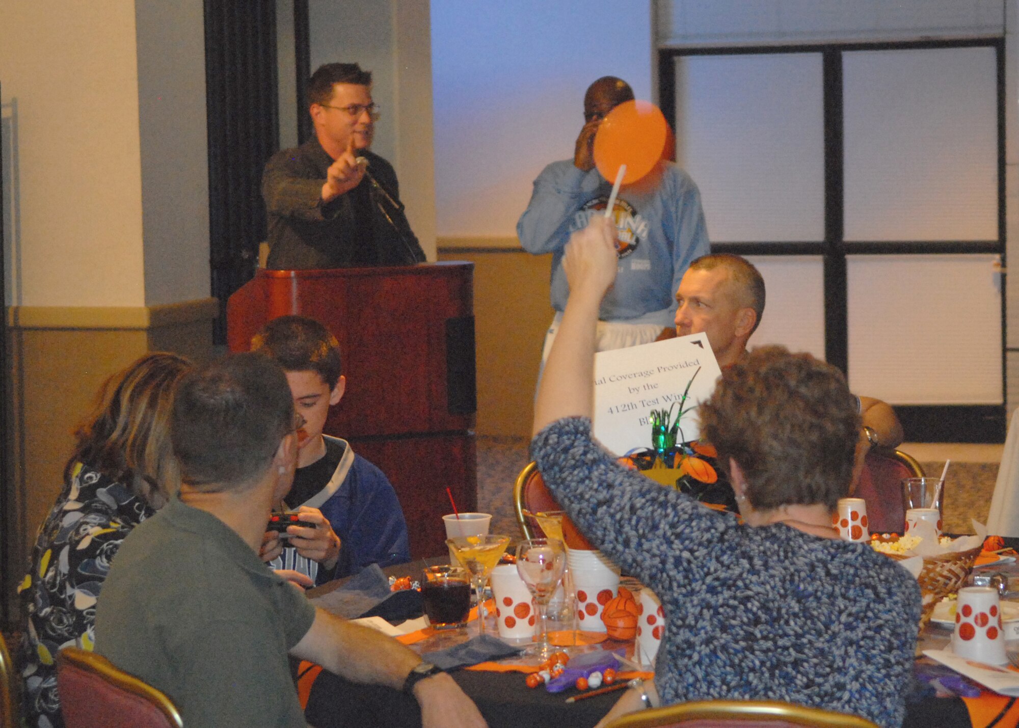 Auctioneer, Airman 1st Class Cole Cargill, acknowledges a participant at the 9th Annual Mad Marchness Charity and Fundraising Auction, held by Edwards Officer's Spouses Club March 19. This year's auction, raised $10,000 for the EOSC. (Air Force photo/Senior Airman William A. O'Brien)