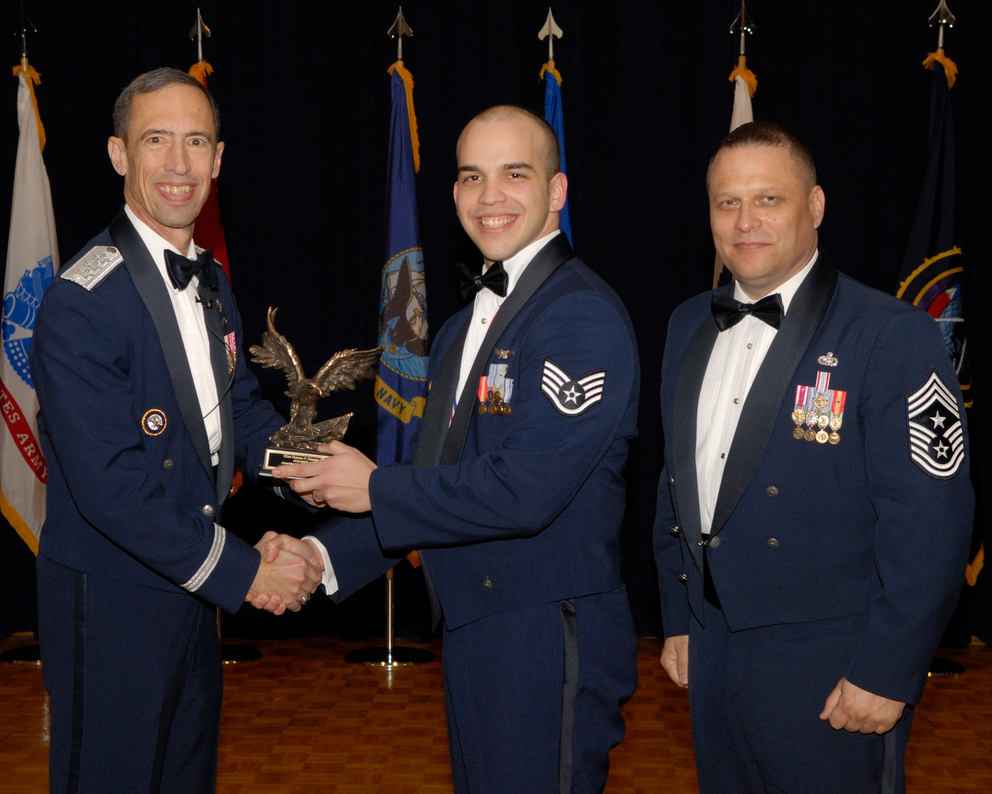 VANDENBERG AIR FORCE BASE, Calif. -- Staff Sgt. Rueben Peralta, with the Joint Functional Component Command for Space, receives the JFCC Space Junior-Tier Enlisted Annual Award from Lt. Gen. Larry James, the 14th Air Force commander, and Chief Master Sgt. James MacKinley, the 14th AF command chief master sergeant, during the 14th Air Force Annual Awards Ceremony at the Pacific Coast Club here Thursday, March 18, 2010.   (U.S. Air Force photo/Senior Airman Andrew Satran) 

 