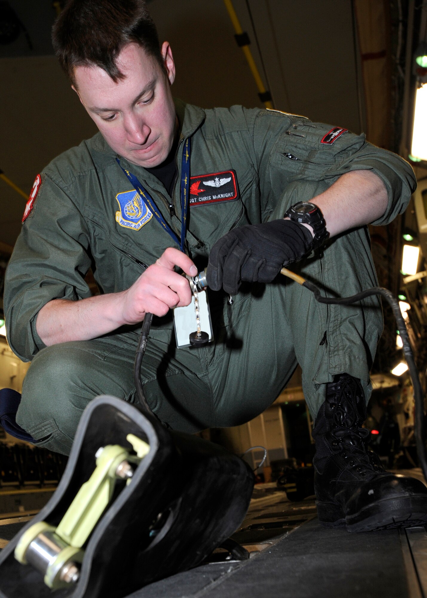 ELMENDORF AIR FORCE BASE, Alaska -- Staff Sgt. Chris McKnight prepares electronic tie down before loading a crate onto a C-17 Globemaster III March 19. Sergeant McKnight and his crew from the 517th Airlift Squadron were participating in a combat simulation improved container delivery drop over Tin City, Alaska. (Air Force photo by Senior Airman Matt Coleman-Foster)