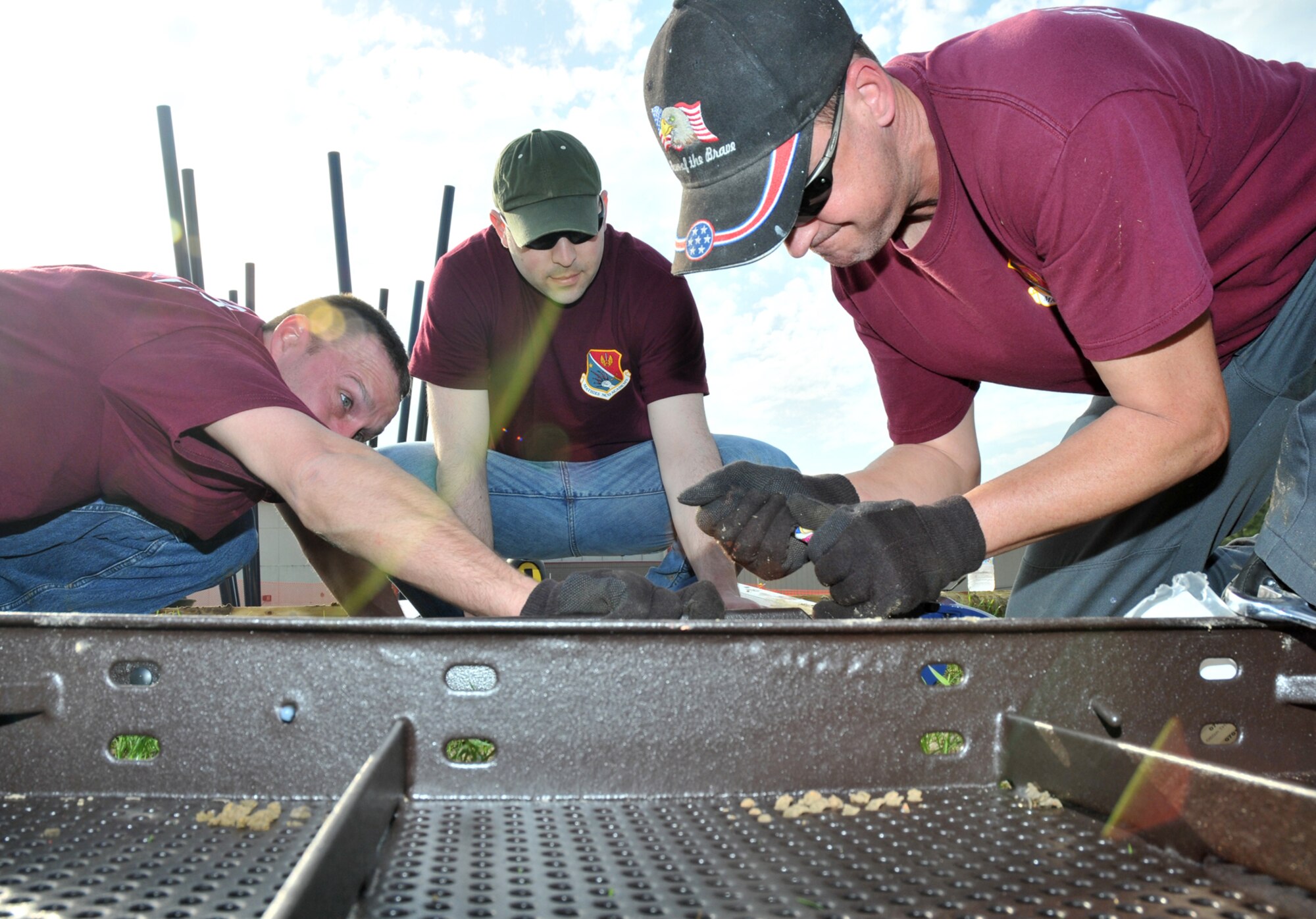 Tech. Sgts. Tim Overcashier, Matt Gebo and Mark Jegel, all from the Mathies NCO Academy, worked on installation of playground equipment.  Officials said the large volunteer turnout saved the school $7,500 in construction costs and helped complete the project in half the expected time.  (U.S. Air Force photo by Adam Bond)

