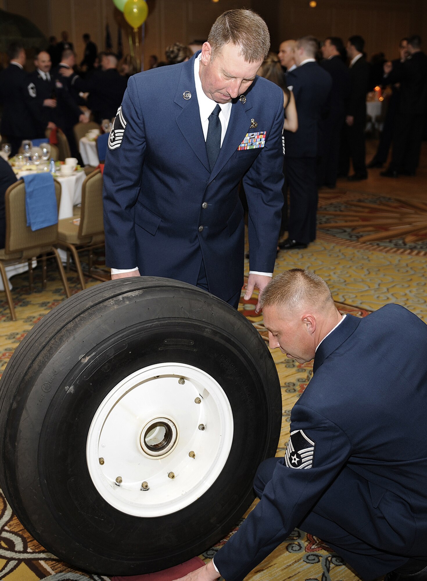 Senior Master Sgt. Ed Rife (standing) and Master Sgt. Edward Falls, Jr., prepare a C-130 Hercules "wheel" as part of the 302nd Maintenance Group's salute to award winners at the 302nd Airlift Wing's annual awards banquet at the Antlers Hitlon in downtown Colorado Springs, Colo. The awards banquet honored the wing's top Airman, non-commissioned officer, senior non-commissioned officer and company grade officer respectively. Sergeant Falls is assigned to the 52nd Airlift Squadron, an active duty unit paired with the 302nd AW as part of Total Force Integration. (U.S. Air Force photo/Craig Denton)