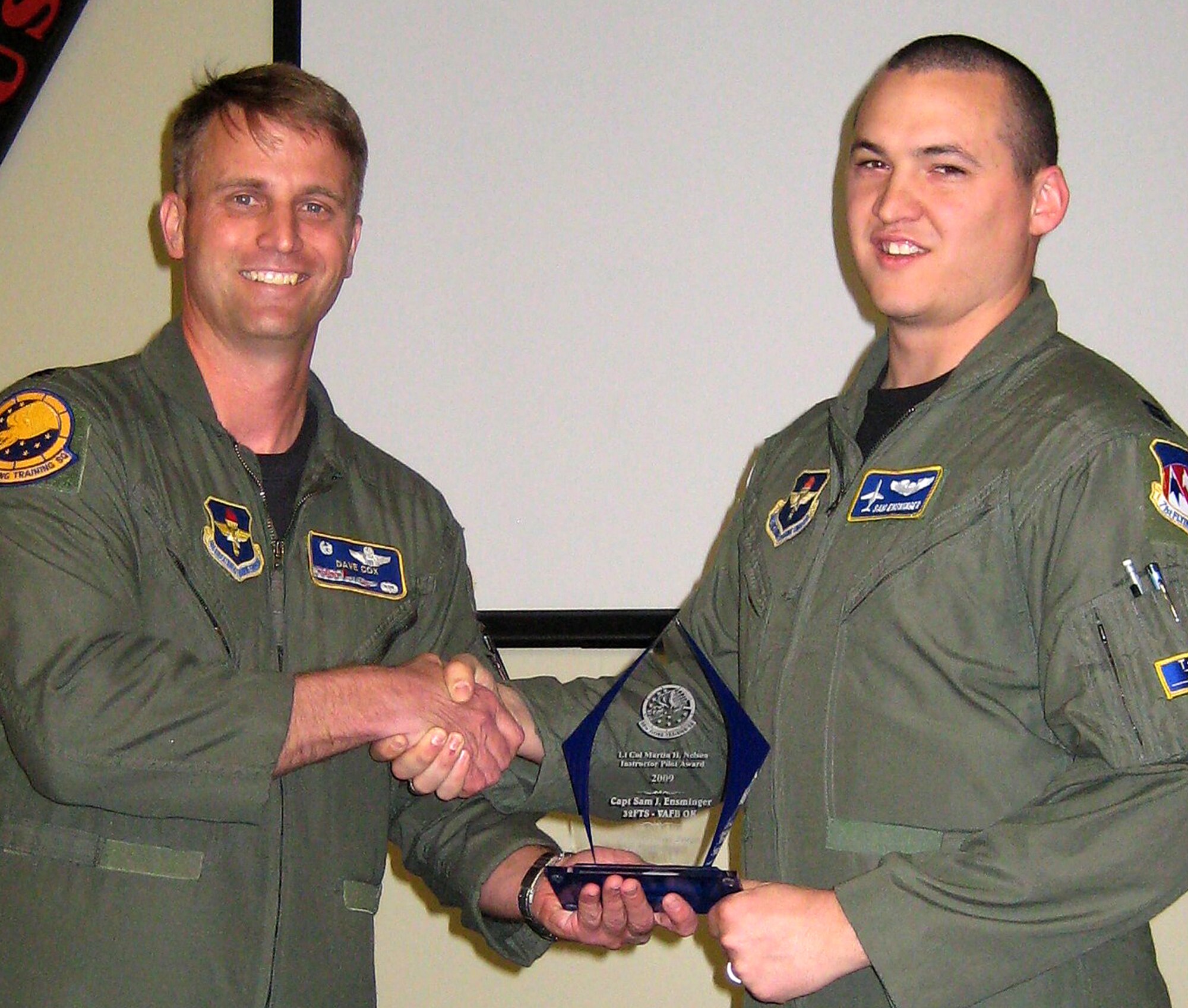 Capt. Sam Ensminger, right, receives the Lt. Col. Martin H. Nelson Instructor Pilot Award from Lt. Col. David Cox, commander of the 99th Flying Training Squadron, Randolph AFB, Texas, during a ceremony at Vance April 18. Captain Ensminger is an instructor pilot with the 32nd Flying Training Squadron here. He also serves as the 71st Mission Support Group executive officer. (U.S. Air Force photo)