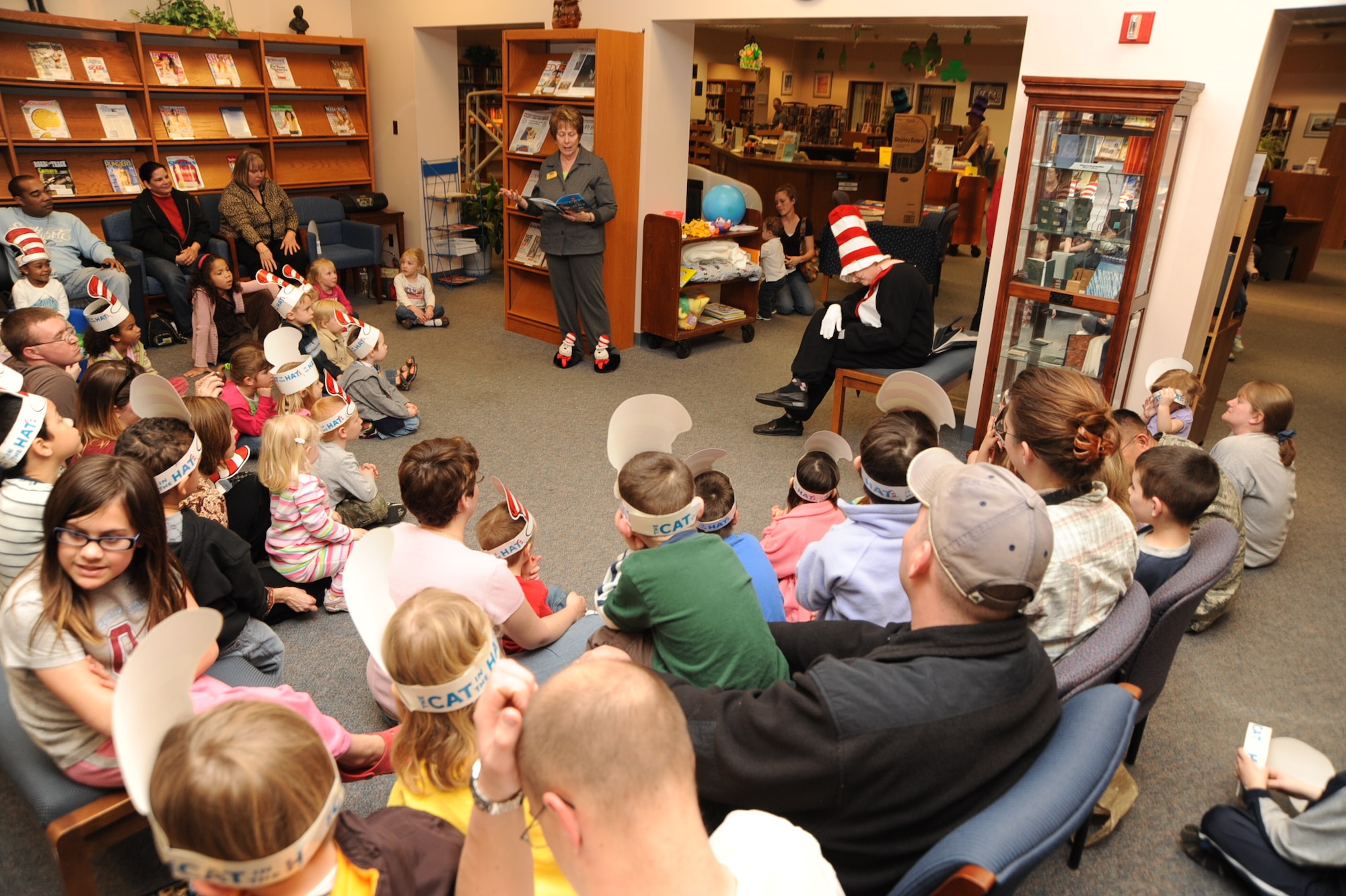 SCOTT AIR FORCE BASE, Ill. -- Sandy Koontz, Scott Library director, reads “The Cat in the Hat” by Dr. Seuss while Dee Bayley, Scott Library lead technician, acts the book out during Cat in the Hat Night March 18. The night brought families together and featured games, prizes and reading.  The Scott Library was named the 2009 Air Force Library Program of the Year. (U.S. Air Force photo/Airman 1st Class Tristin English) 