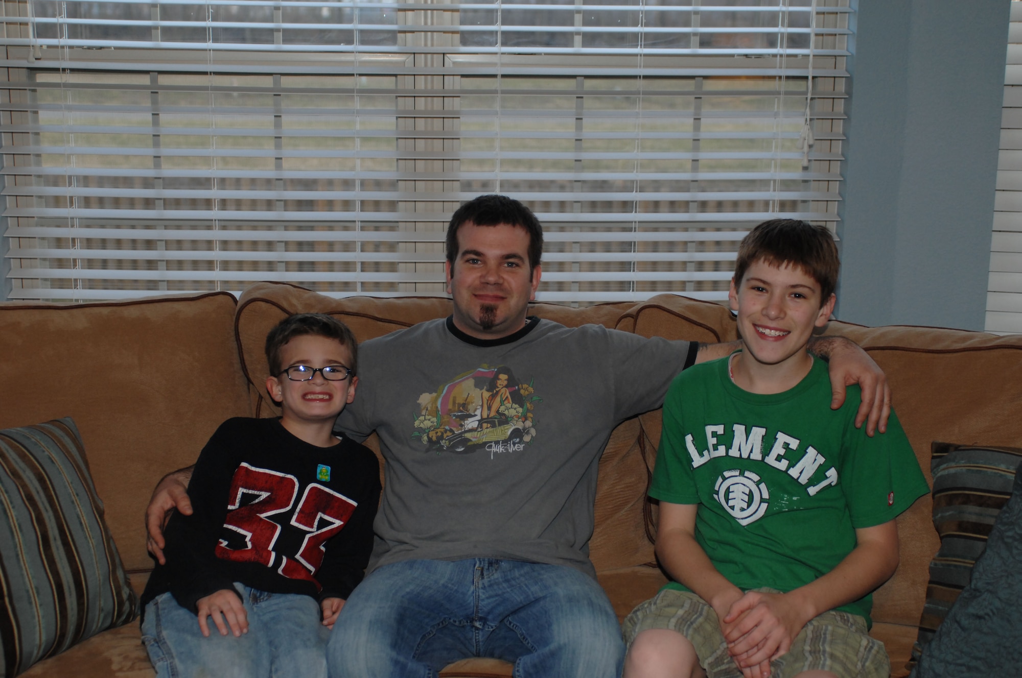 SCOTT AIR FORCE BASE, Ill. -- Greg Henry, center, sits with is children, Charles, 14, and Kai, 8, at their O'Fallon home. Mr. Henry is currently serving in the role as a father and mother, while his wife is serving in Afghanistan. (U.S. Air Force photo/Airman 1st Class Amber Kelly-Herard)