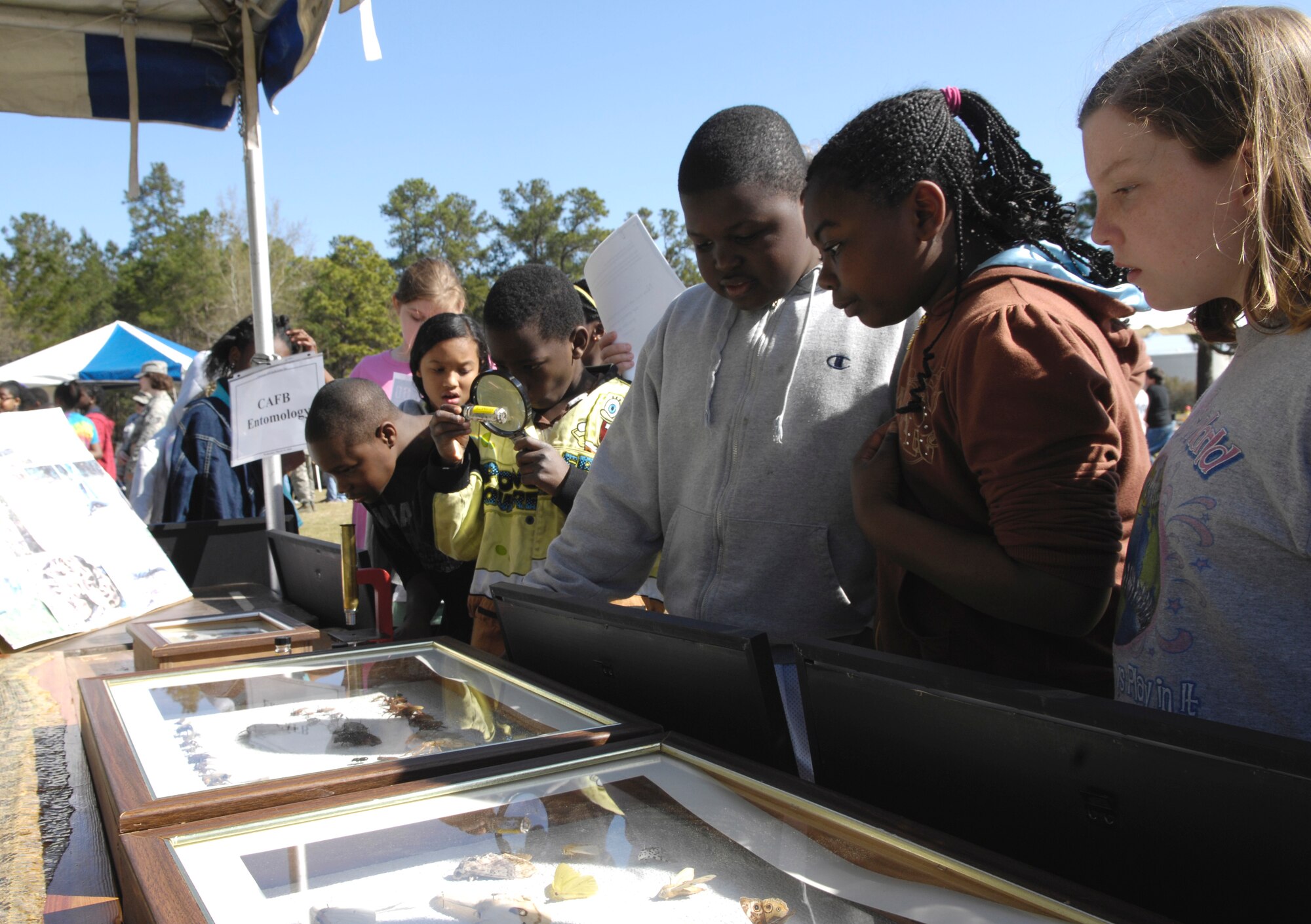 Students from Hunley Park Elementary School observe glass cases filled with preserved bugs at the entomology booth during the 14th annual Earth Day festival held on Joint Base Charleston, S.C., March 24, 2010. The students rotated through 27 different booths that were manned by different organizations that protect South Carolina's wildlife and environment. Eight different elementary schools attended the event with approximately 700 students total. (U.S. Air Force Photo/Airman 1st Class Lauren Main)