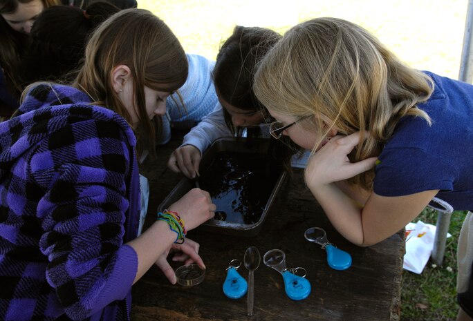 Haley Finley, Skylar Worrill and  Kailey Wright pick through swamp water in a pan while searching for bugs and worms during the Earth Day festivities on Joint Base Charleston, S.C., March 24, 2010. This Earth Day marks the 14th annual festival that celebrates Earth day in conjunction with Arbor Day. Arbor Day was originally founded by J. Sterling Morton in 1872. All 50 states as well as numerous countries recognize the holiday that encourages individuals to plant trees and care for mother nature. Haley, Skylar and Kailey are all students from Stiles Point Elementary School. (U.S. Air Force Photo/Airman 1st Class Lauren Main)
