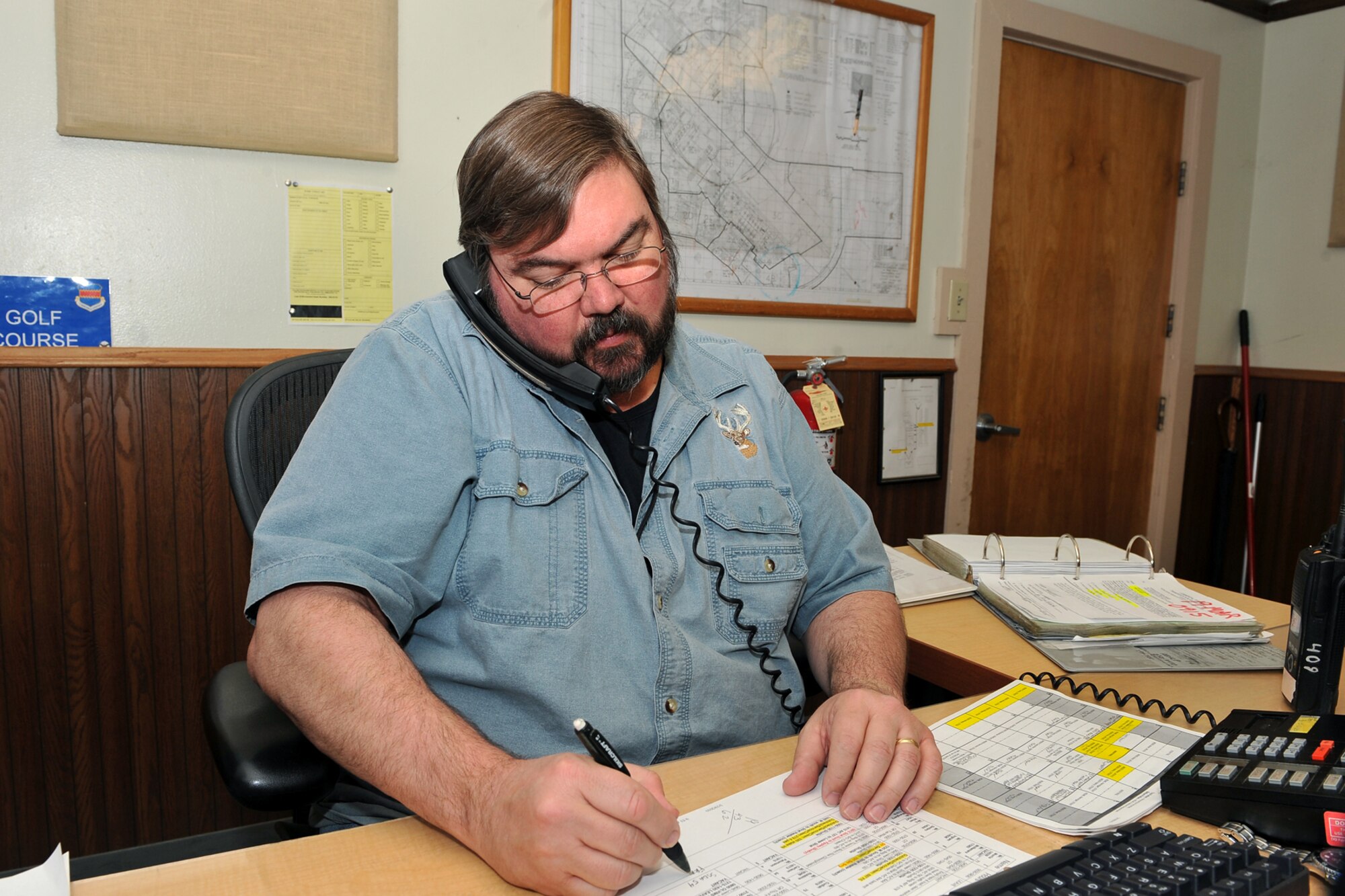 OFFUTT AIR FORCE BASE, Neb. - Mark "Gus" Gustafson, a vehicle dispatcher with the 55th Mission Support Group's Logistics Support Division, receives a call from a customer inside the vehicle operations office March 19. The division's vehicle operations section takes care of Offutt's transportation needs using a fleet of more than 60 vehicles.  

U.S. Air Force photo by Charles Haymond