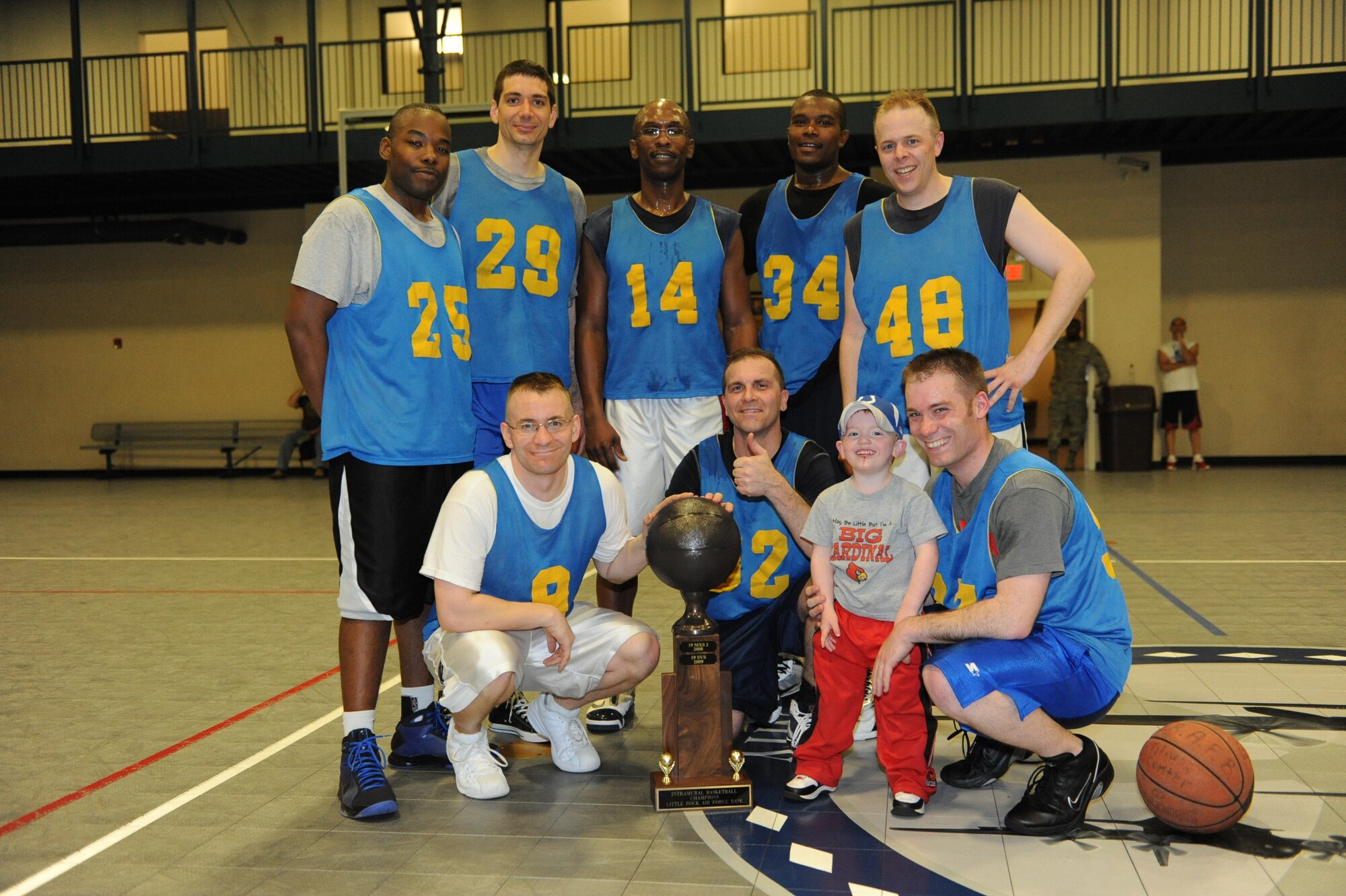 The 19th Airlift Wing staff team celebrates their intramural basketball championship March 19 at the base fitness center. (U.S. Air Force photo by Senior Airman Ethan Morgan)