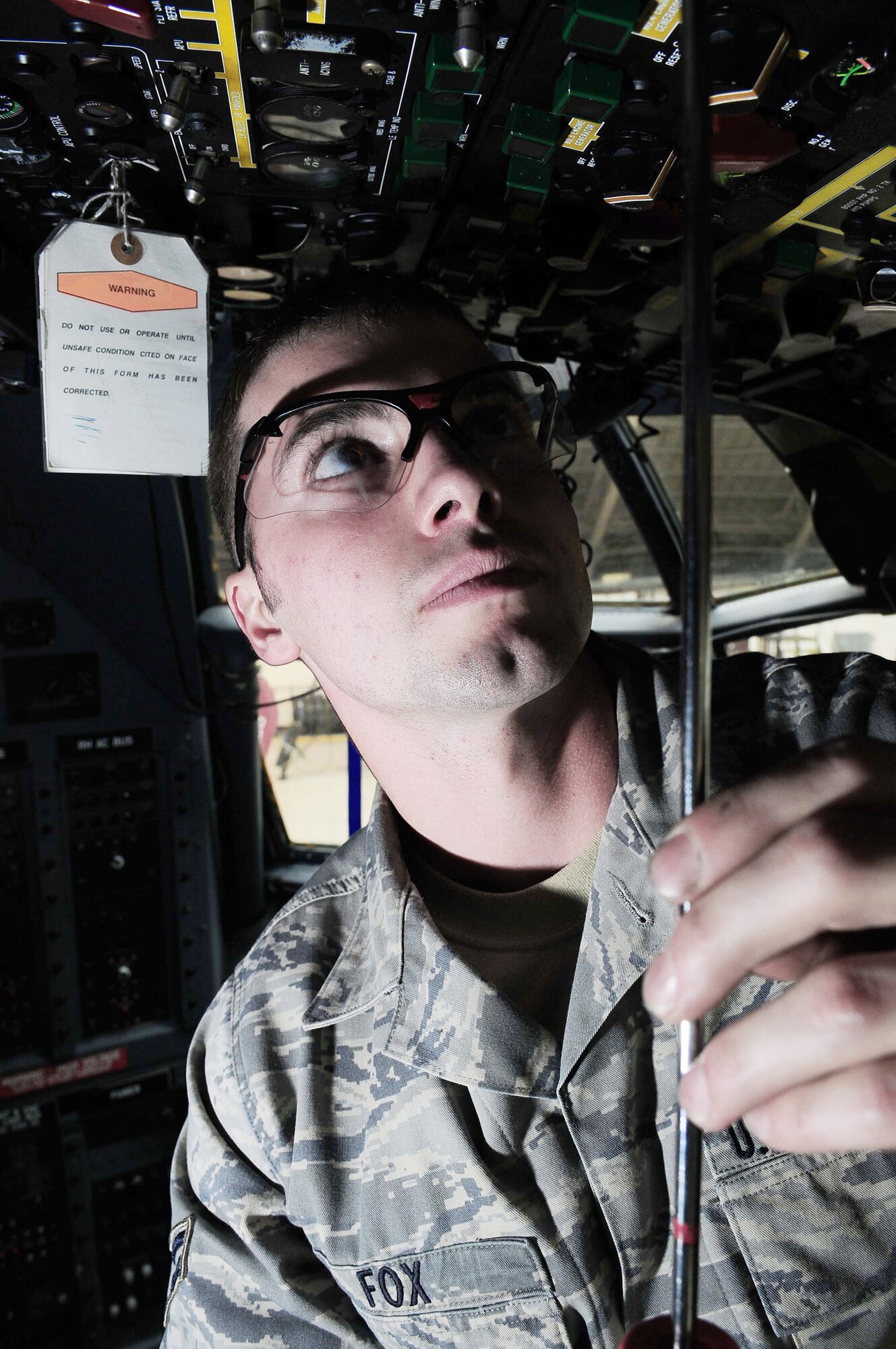 Airman 1st Class Branden Fox lowers an overhead instrument panel in the cockpit of a C-130 Hercules March 16, 2010, at Yokota Air Base, Japan. Airman Fox is a 374th Maintenance Squadron crew chief. (U.S. Air Force photo/Airman 1st Class Devin Doskey)