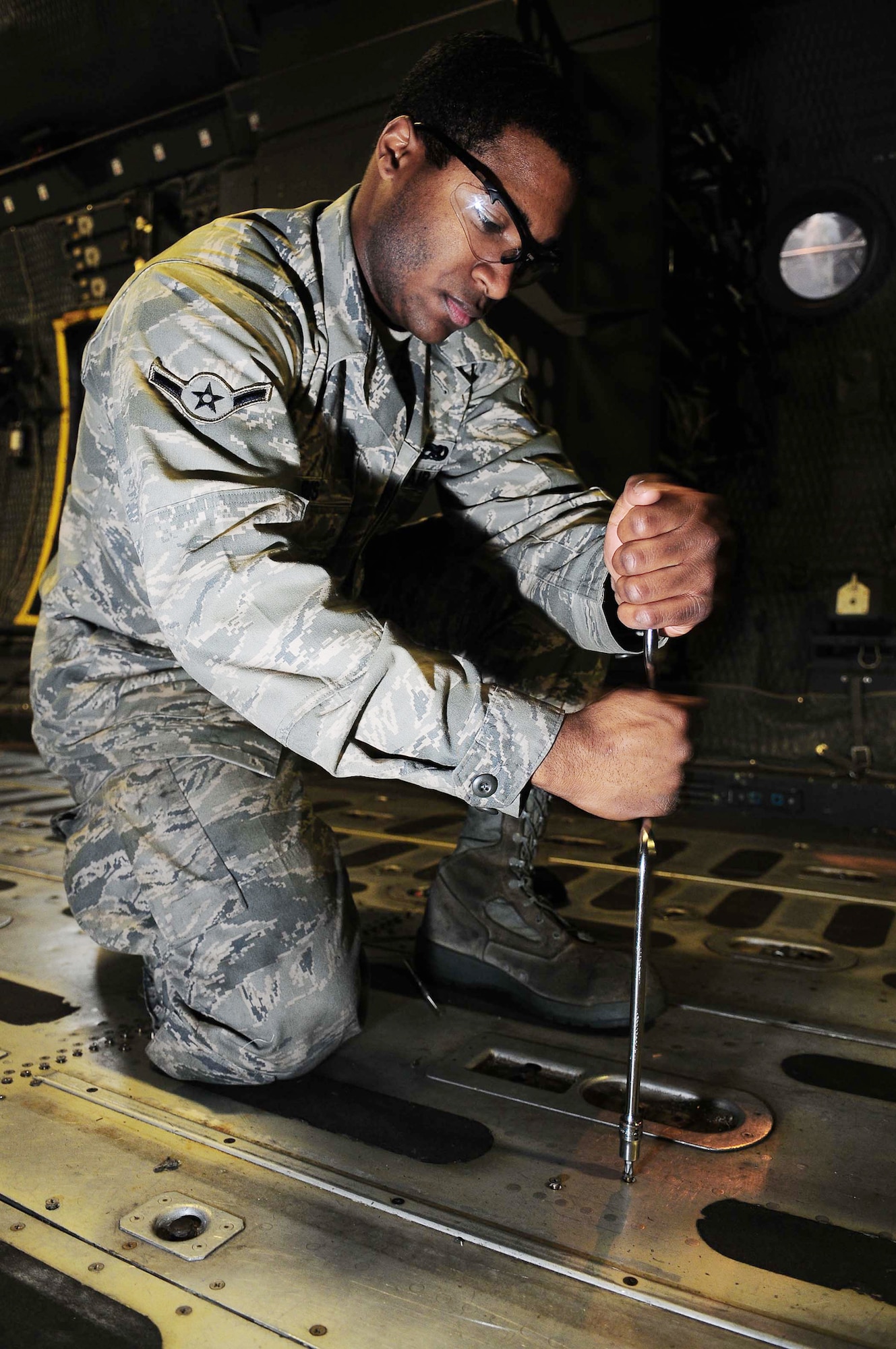Airman Shannon Harris pulls up a floor panel from a C-130 Hercules March 16, 2010, at Yokota Air Base, Japan. Airman Harris is a 374th Maintenance Squadron crew chief. (U.S. Air Force photo/Airman 1st Class Devin Doskey)