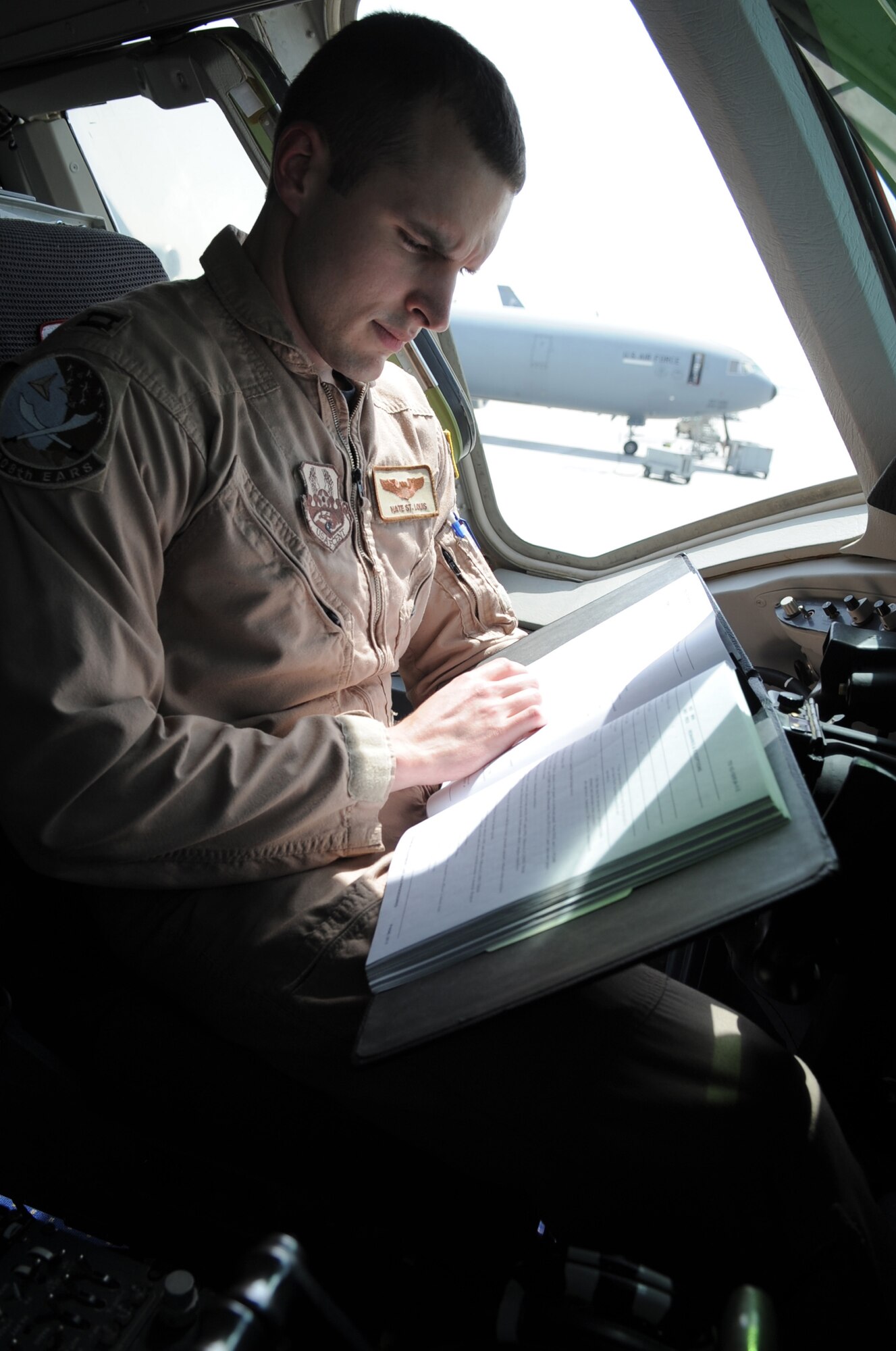 Capt. Nate St. Louis, KC-10 Extender piliot and assistant operations officer for the 908th Expeditionary Air Refueling Squadron, works on the flight deck of a KC-10 at a non-disclosed base in Southwest Asia on March 24, 2010. Captain St. Louis is deployed from the 32nd Air Refueling Squadron at Joint Base McGuire-Dix-Lakehurst, N.J., and his hometown is China Grove, N.C. (U.S. Air Force Photo/Master Sgt. Scott T. Sturkol/Released)