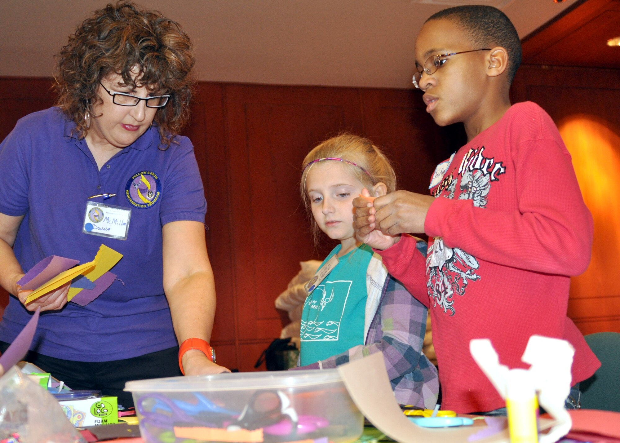 Donna McMillan, a personnel readiness employee for the 917th Mission Support Flight on Barksdale Air Force Base, La., aids an Air Force dependant in decorating her homemade greeting card for her recently deployed parent during a Yellow Ribbon Reintegration Program event March 20, 2010. McMillan was one of the volunteers from the 917th Wing at the American Airlines Training and Conference Center in Fort Worth, Texas, and was assigned to the youth activities section. (U.S. Air Force Photo/Senior Airman Crystal Marie Jordan)