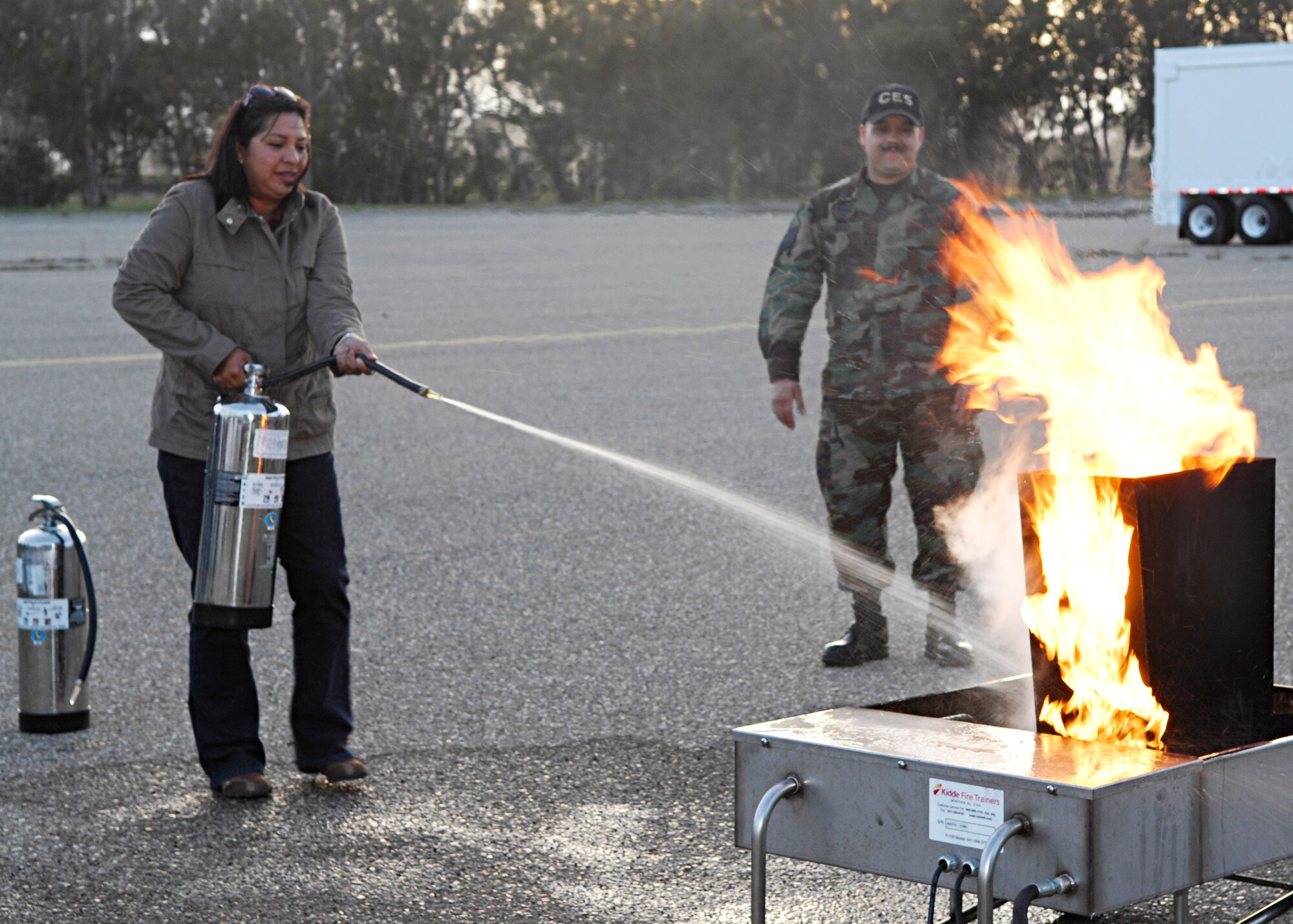VANDENBERG AIR FORCE BASE, Calif. -- Treasea Landreth, spouse of Tech. Sgt. Paul Landreth of the 30th Security Forces Squadron, practices her fire extinguisher techniques while Master Sgt. Juan Valle of the 30th Civil Engineer Squadron watches during training here Thursday, March 18, 2010. The training was provided to ensure base childcare providers know how to use fire extinguishers in case of an emergency. (U.S. Air Force photo/Senior Airman Heather R. Shaw)
