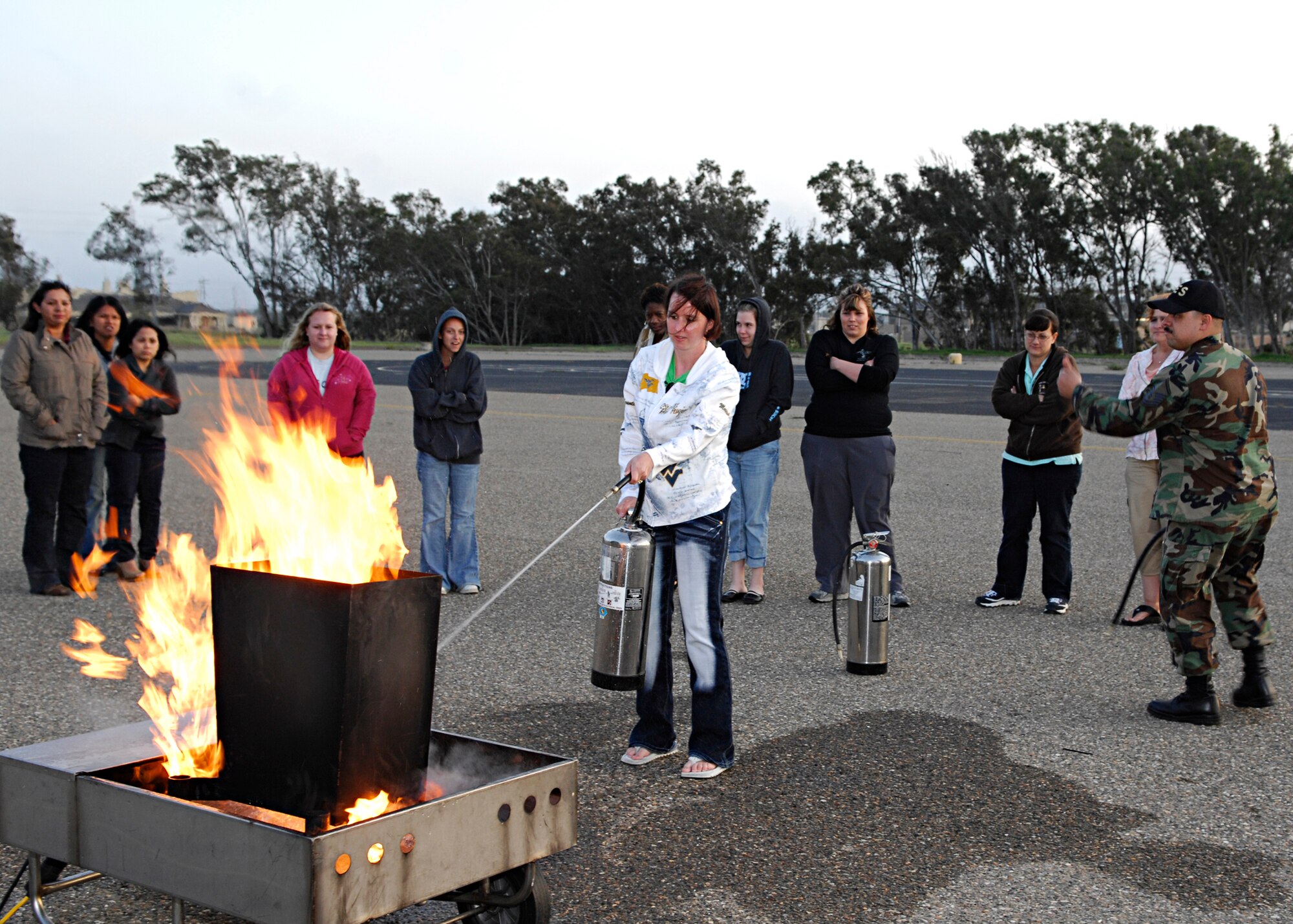 VANDENBERG AIR FORCE BASE, Calif. -- Master Sgt. Juan Valle, a fire prevention chief from the 30th Civil Engineer Squadron, gives a thumbs up to show that Bianca Setliff, spouse of Tech. Sgt. David Setliff of the 30th Security Forces Squadron, is using proper fire extinguisher techniques here Thursday, March 18, 2010. Mrs. Setliff attended the training that was provided to show child care providers proper safety techniques. (U.S. Air Force photo/Senior Airman Heather R. Shaw)
