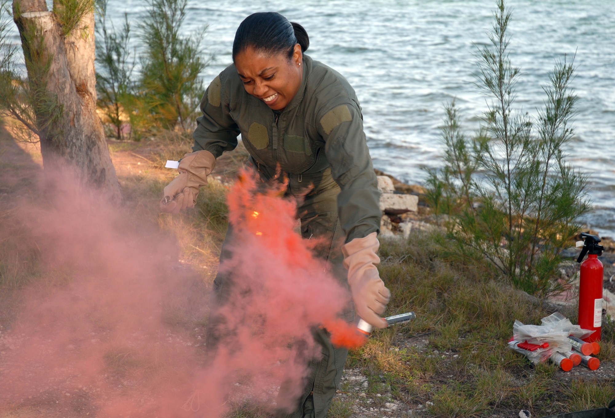 Senior Master Sgt. Vondella Stevens-Maynard, 201st Airlift Squadron flight attendant, pops a day flare during water survival training at Naval Air Station Key West, Fla. Mar. 15. (U.S. Air Force photo by Tech. Sgt Tyrell Heaton/Released)