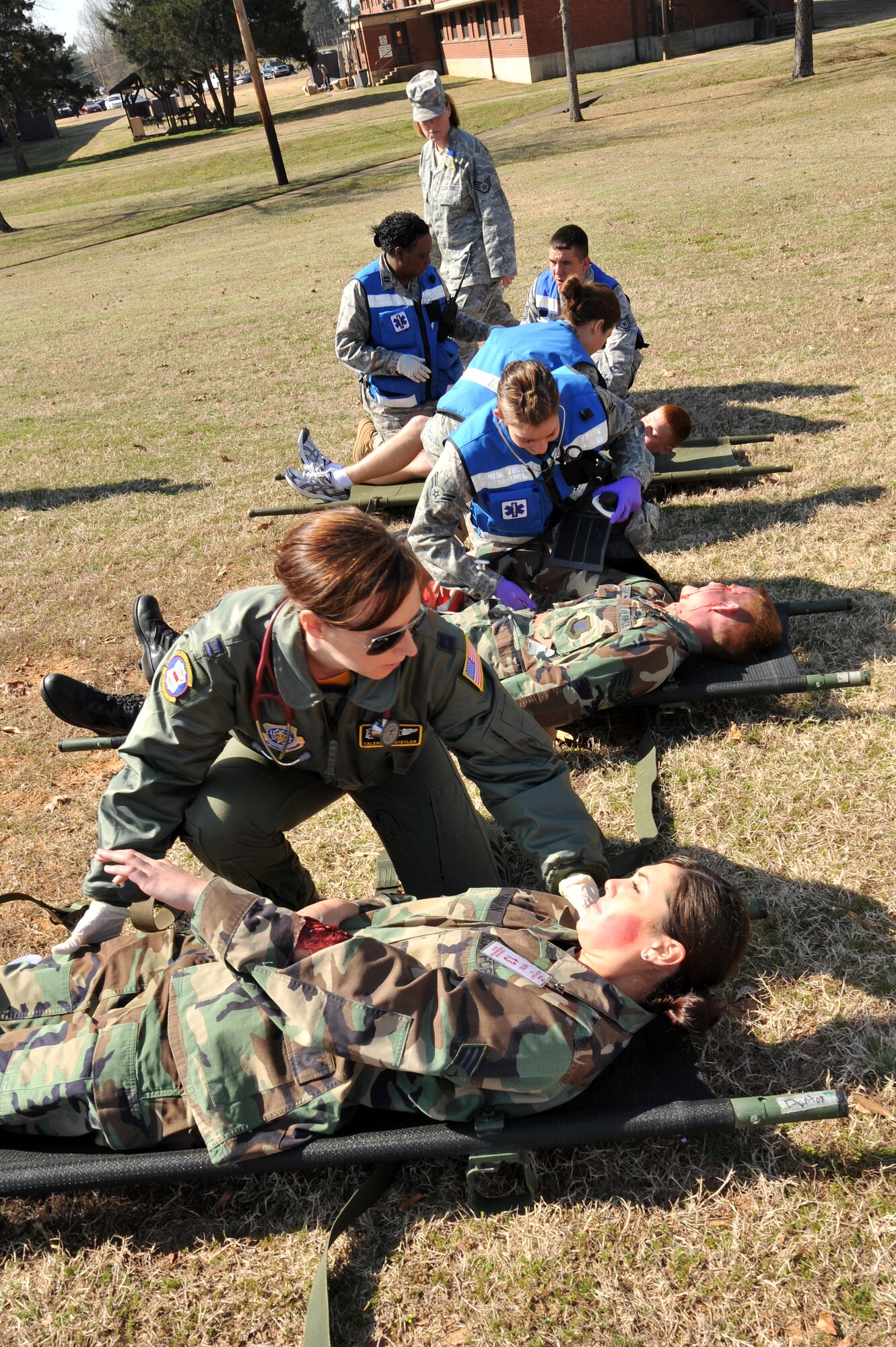 Capt. Valerie Hostetler, 19th Medical Group flight surgeon, checks over Senior Airman Danielle Carrion, 19th Logistic Readiness Squadron supply craftsman, while members of the Emergency Medical Team provide care to other victims of the simulated bomb attack March. Base agencies participated in the March 19 Major Accident Response Exercise in preparation for the 19th Airlift Wing’s upcoming Unit Compliance Inspection in April. (U.S. Air Force Photo by Senior Airman Chris Willis)