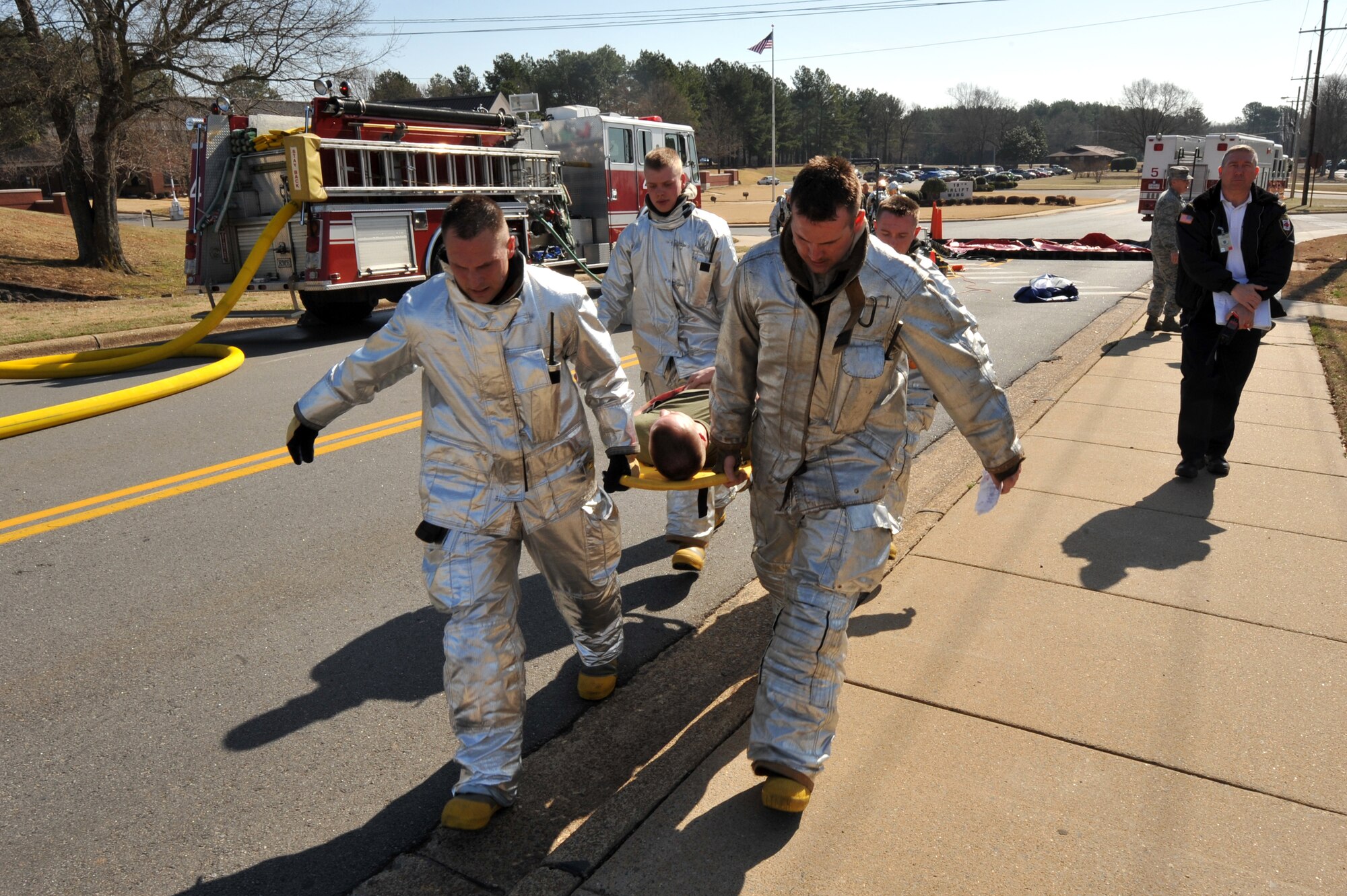 Capt. Alan Laughy, Staff Sgt. Steven Maddox, Airman 1st Class Wesley Stalvey and Airman 1st Class Cody Trosky, 19th Civil Engineer Squadron Fire Fighters, transport Marine Lance Cpl. Zack Dick, Marine Detachment Four barracks member, from a decontamination point to the Emergency Medical Team after a bomb attack "injured" him. Base agencies participated in the March 19 Major Accident Response Exercise to stay current with their training and prepare for real-world event. (U.S. Air Force Photo by Senior Airman Chris Willis)