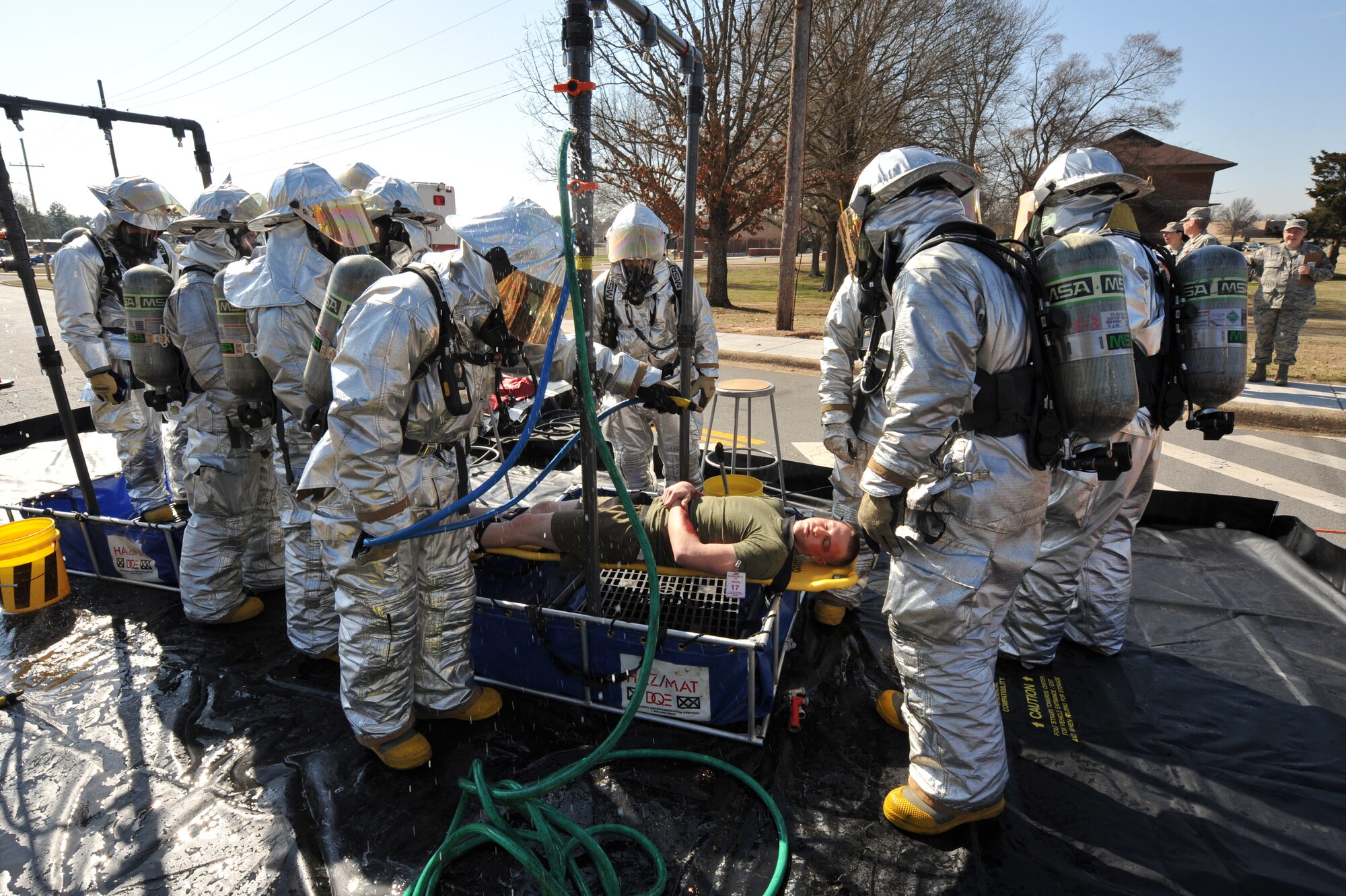 Base firefighters carry Marine Lance Corporal Zack Dick , Marine Detachment Four barracks member,  through the mobile decontamination center after a mock chemical bomb attack on March 19, 2010 during the Major Accident Response Exercise. (U.S. Air Force Photo by Senior Airman Chris Willis)