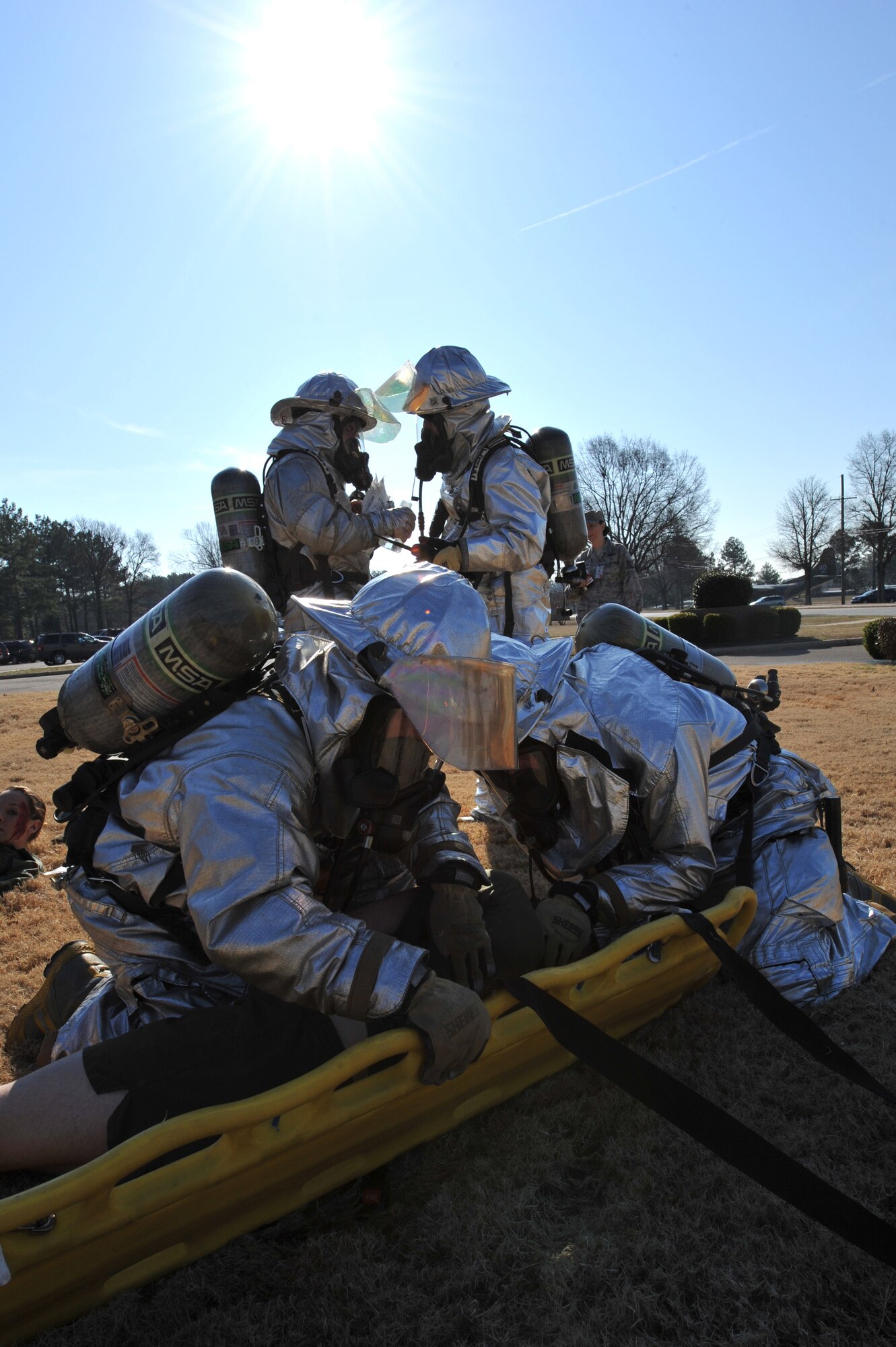 Base firefighters, place Marine Lance Cpl. Zack Dick , Marine Detachment Four barracks member,  onto a stretcher after he was severely injured during a simulated bomb attack outside Little Rock Air Force Base headquarters. Firemen reacted to several mock events on March 19 with other base personnel to stay current with their training.  (U.S. Air Force Photo by Senior Airman Chris Willis)