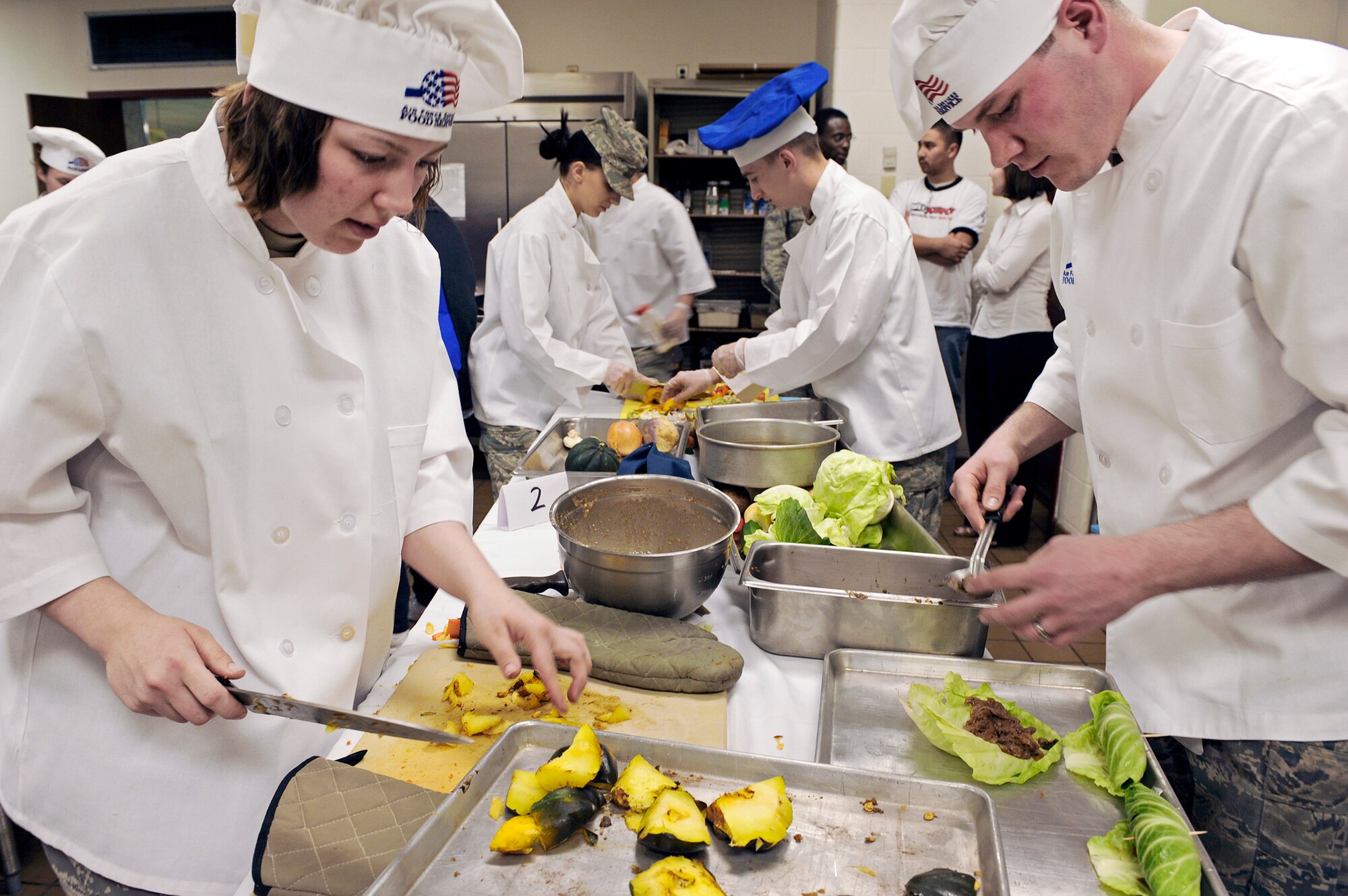 Airman 1st Class Tiffany Lamb and Airman Resse Audette prepare an entr?e and dessert for the second annual "Ellsworth Iron Chef" competition March 17, 2010, at Ellsworth Air Force Base, S.D. Airmen Lamb and Audette along with Airman 1st Class Brent Smith won the competition and were given professional knife sets as prizes. Airmen Lamb, Smith and Audette are 28th Force Support Squadron food services technicians. (U.S. Air Force photo/Senior Airman Marc I. Lane)
